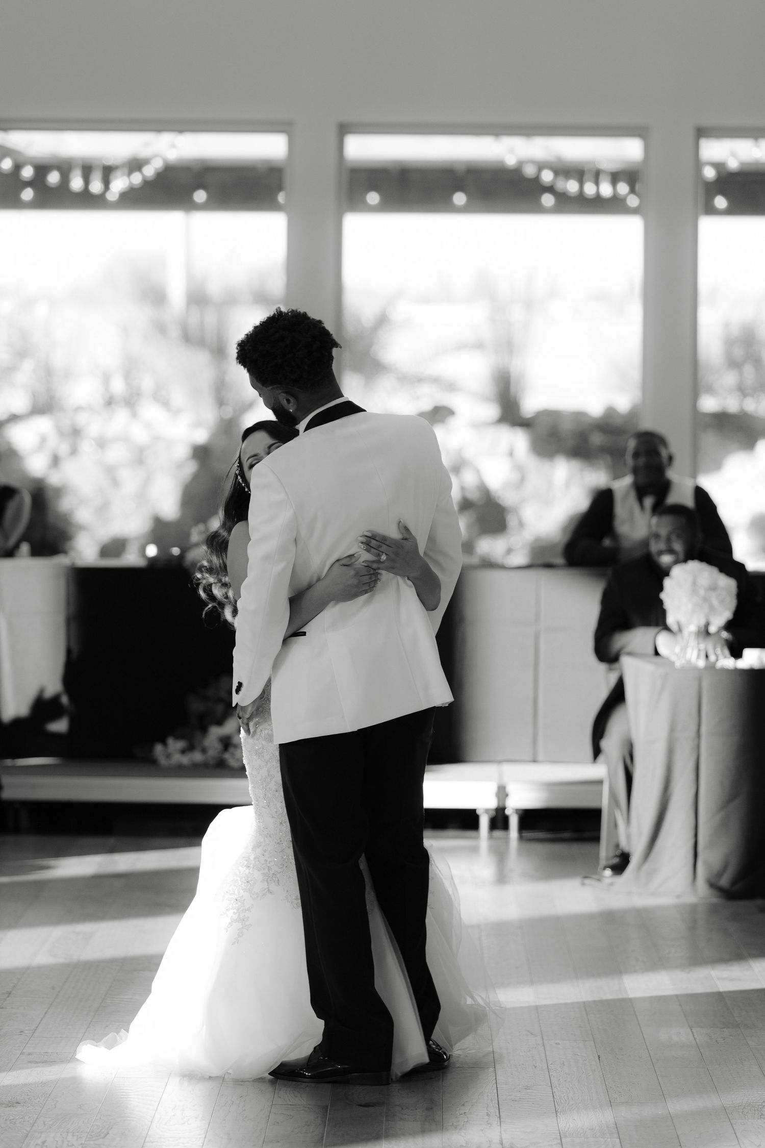 A romantic black and white wedding dance scene showing couples swaying together on a reception dance floor.