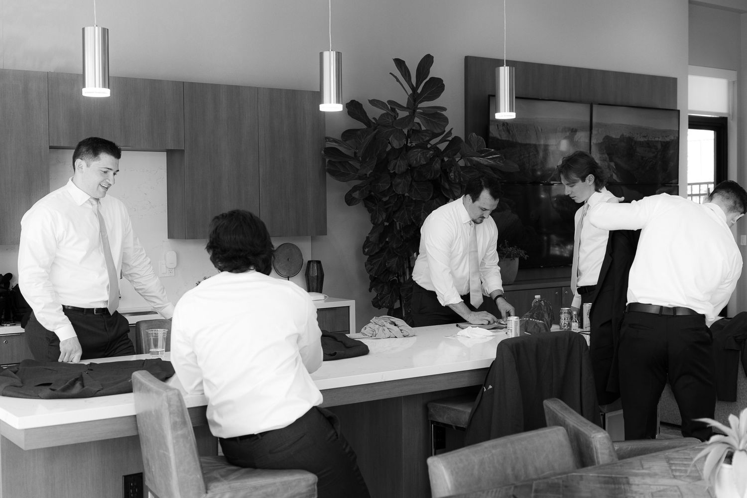 Medical professionals work at desks in a modern office space with pendant lighting and white furnishings.