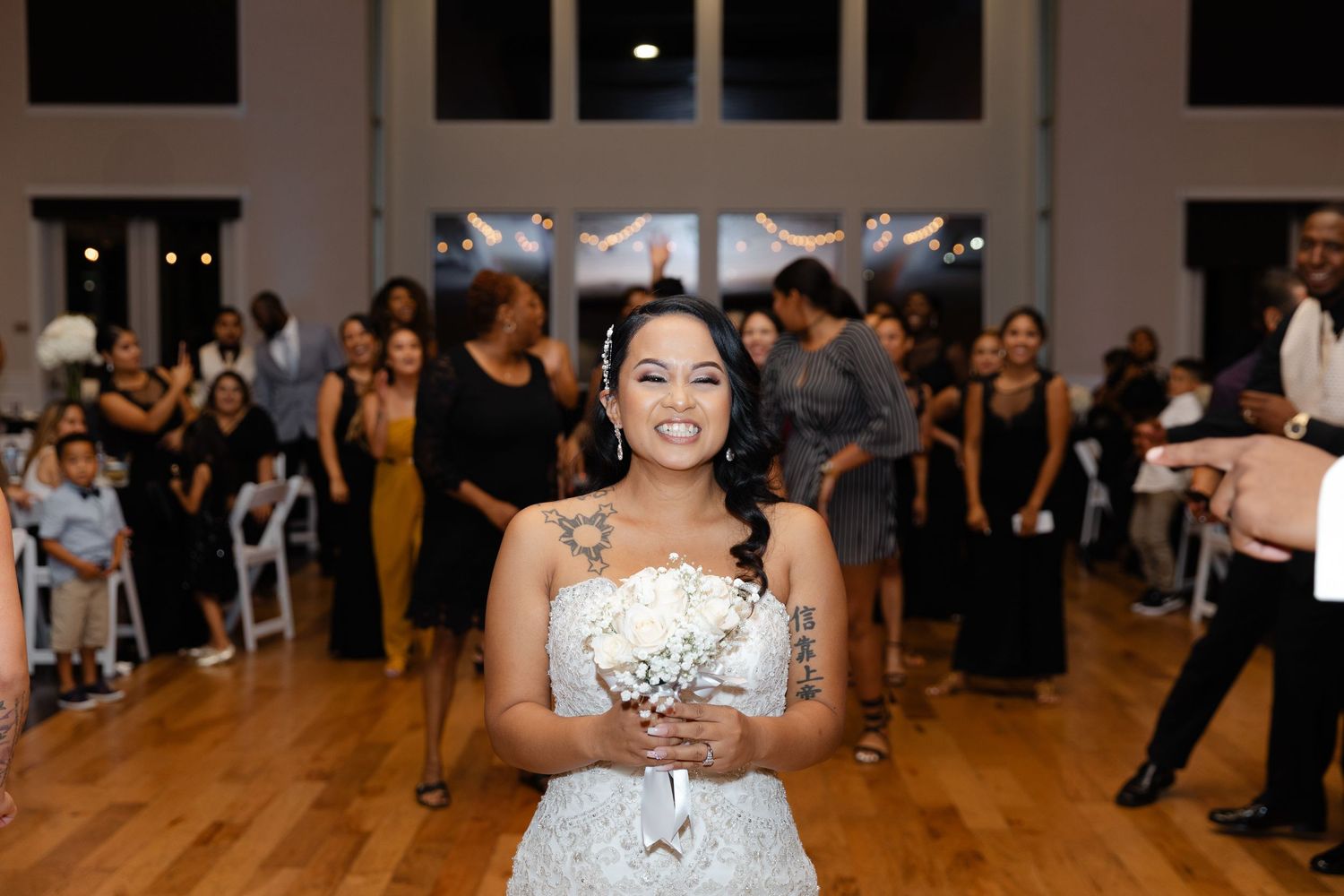 A dancer in a white sequined dress performs energetically during a ballroom dance competition.