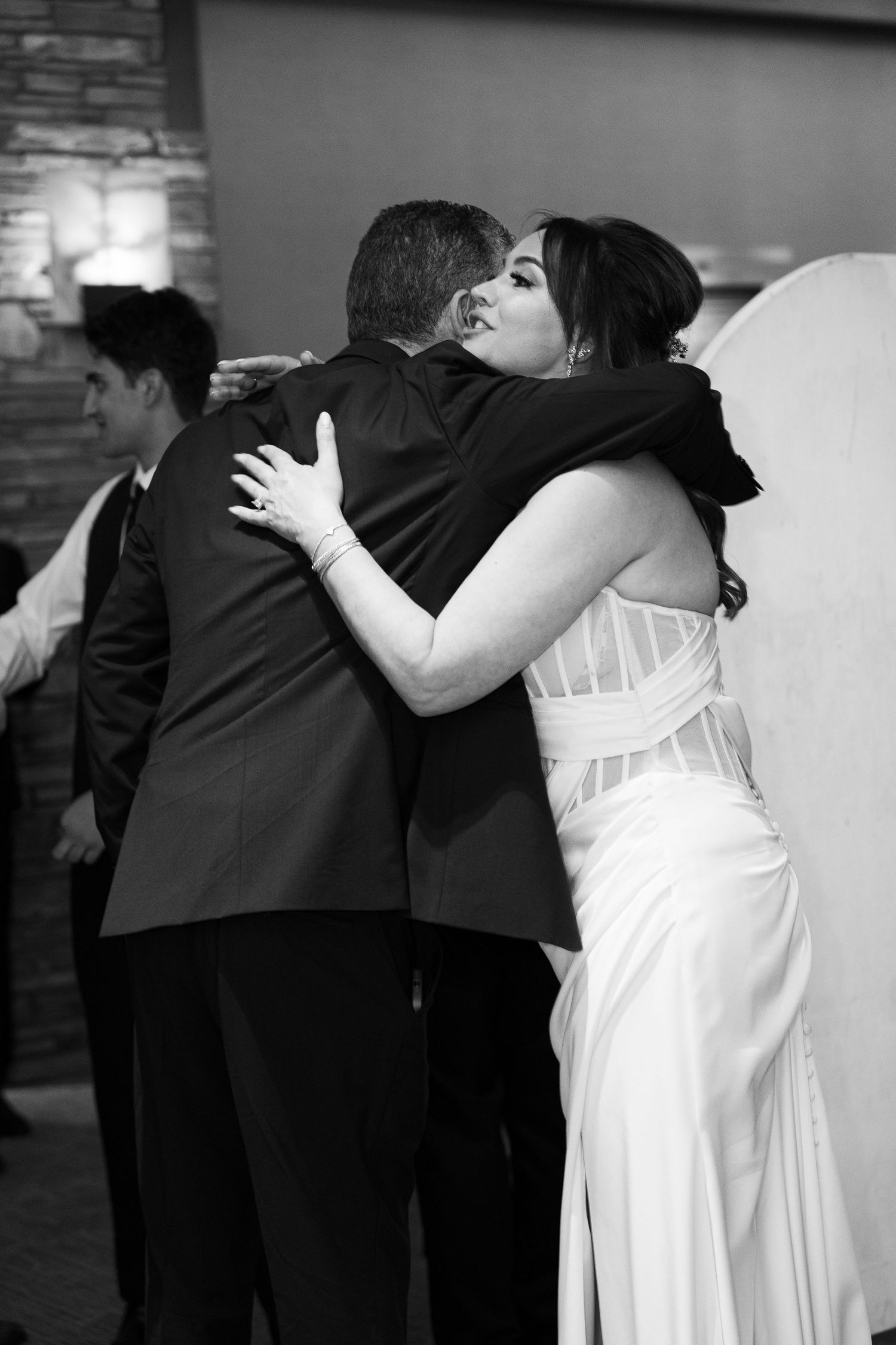 A series of black and white photos showing a couple embracing during a romantic dance sequence at a wedding reception.