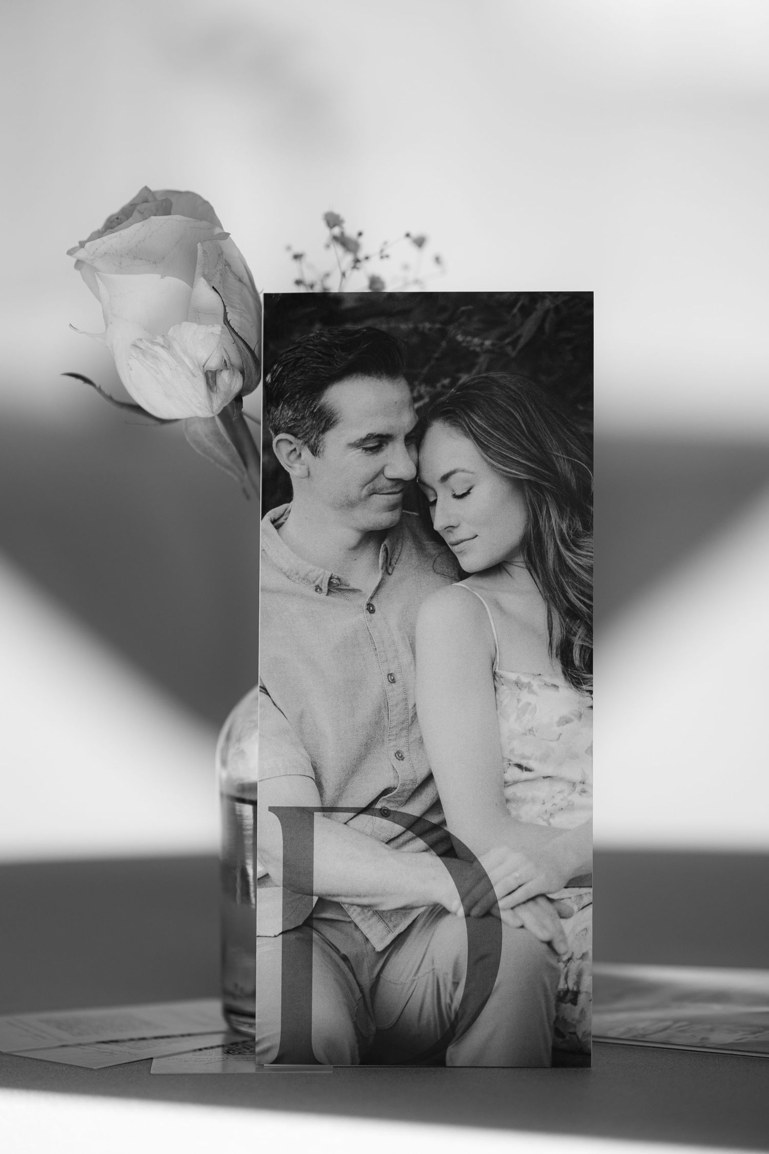 A romantic black and white photo series showing a couple embracing and sharing intimate moments on a couch.