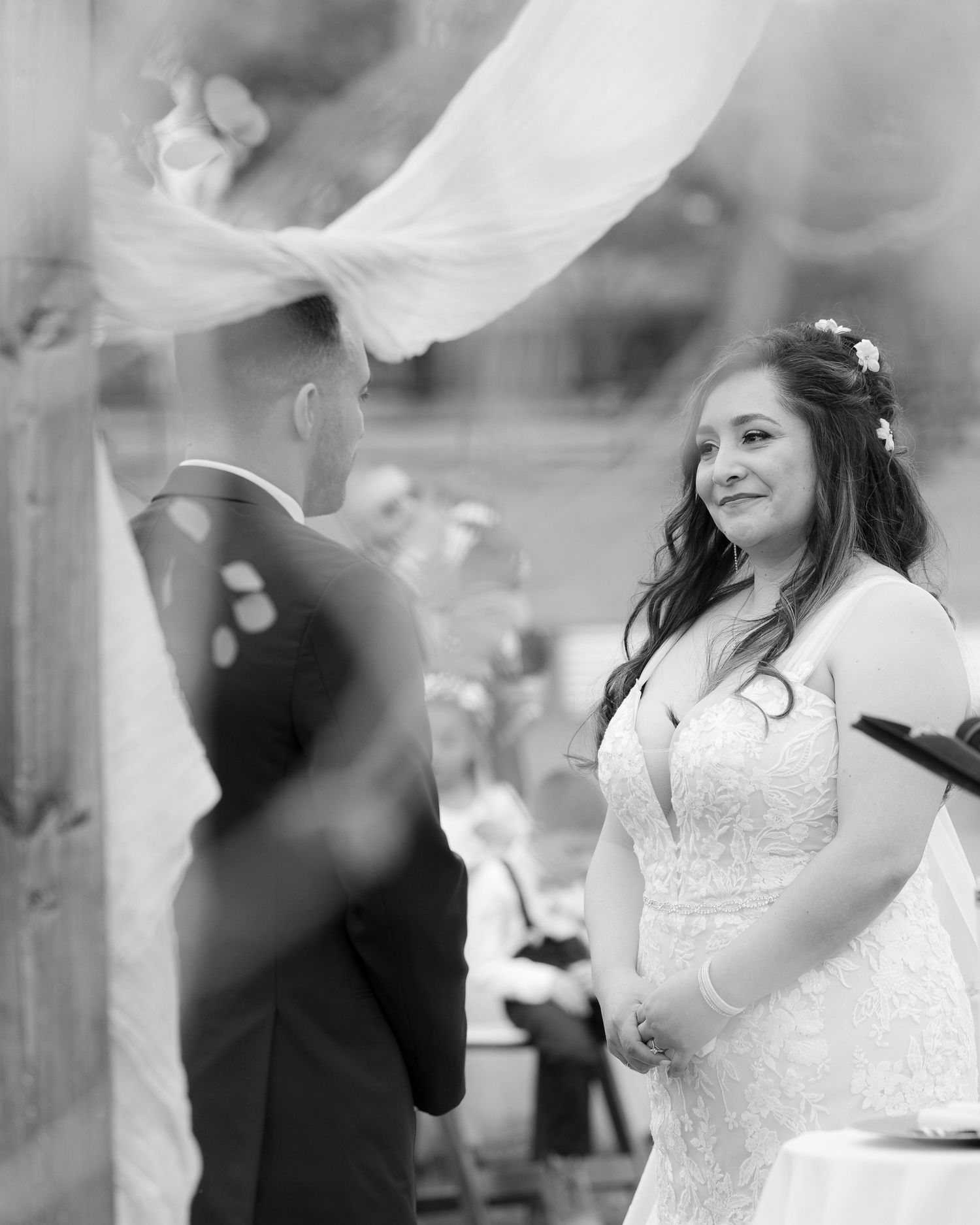 A joyful wedding moment captured in black and white as a bride dances with her veil flowing through the air.
