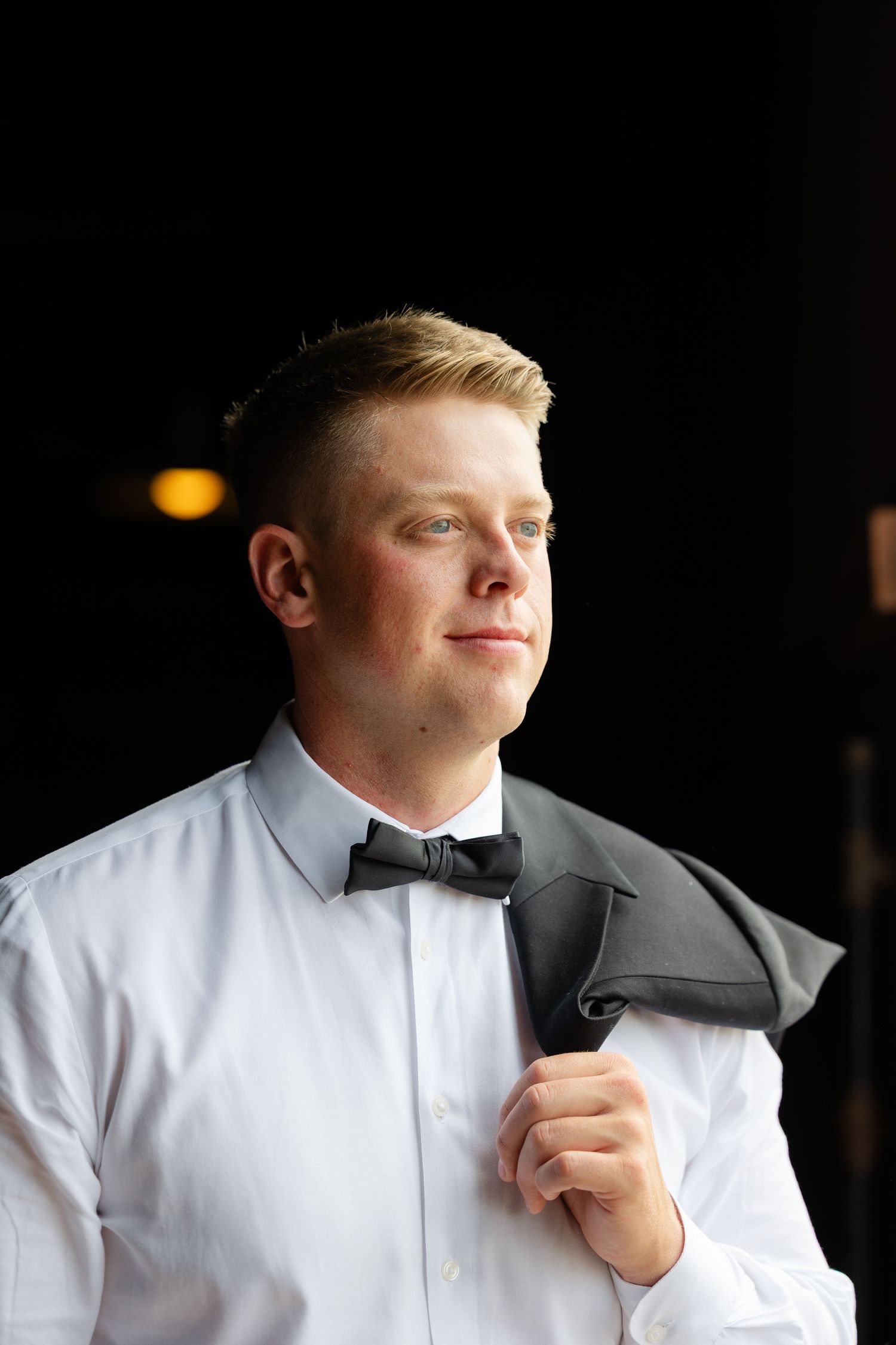 A person in a white dress shirt adjusts their black bow tie in a sequence of close-up shots.