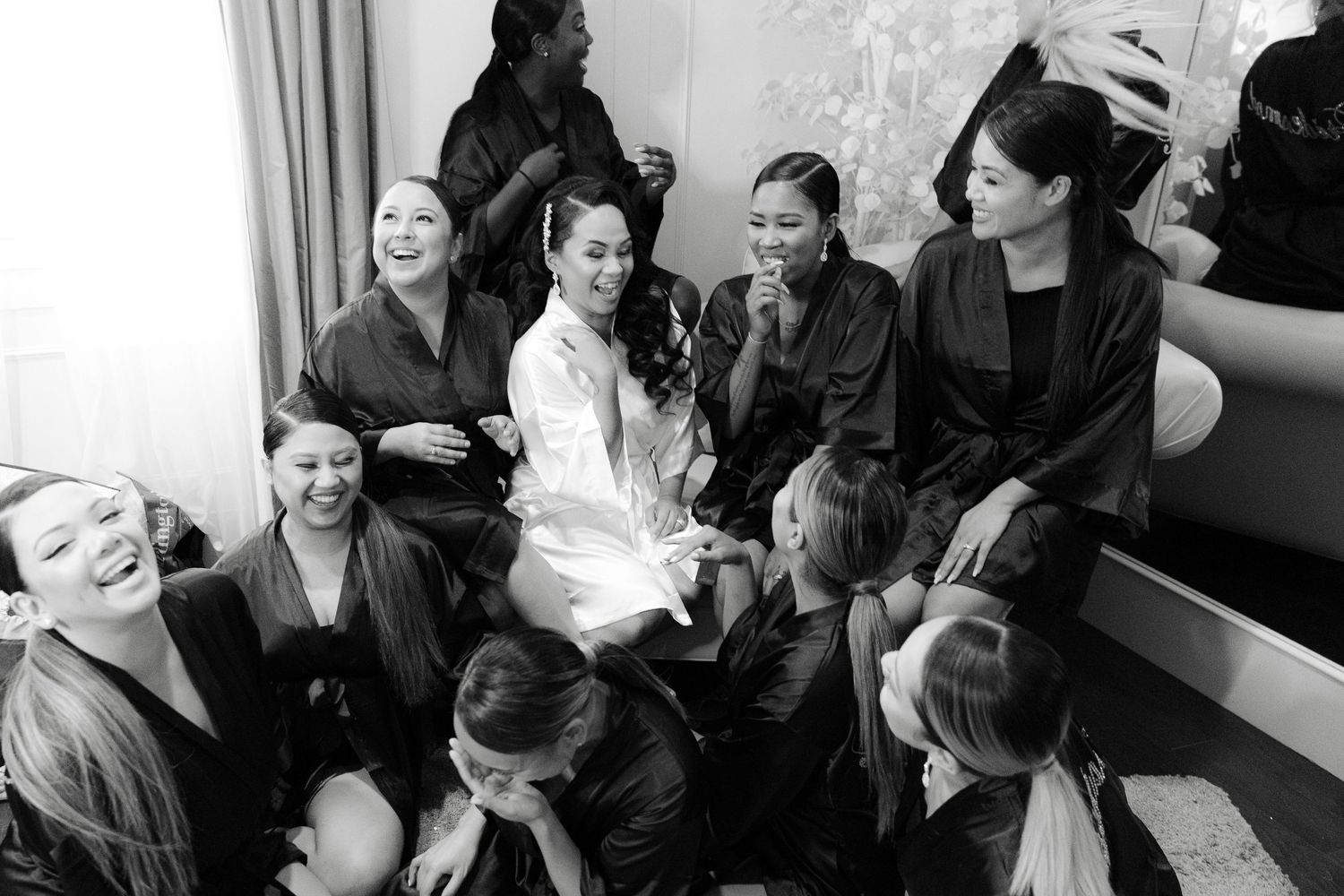 A group of people sitting in a row laughing and engaging in conversation during a casual gathering.