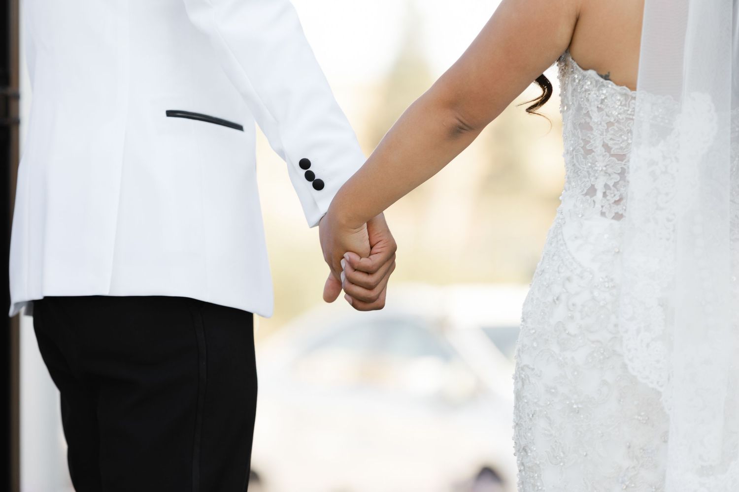 Professional couple in formal attire standing together and smiling in a bright indoor setting.