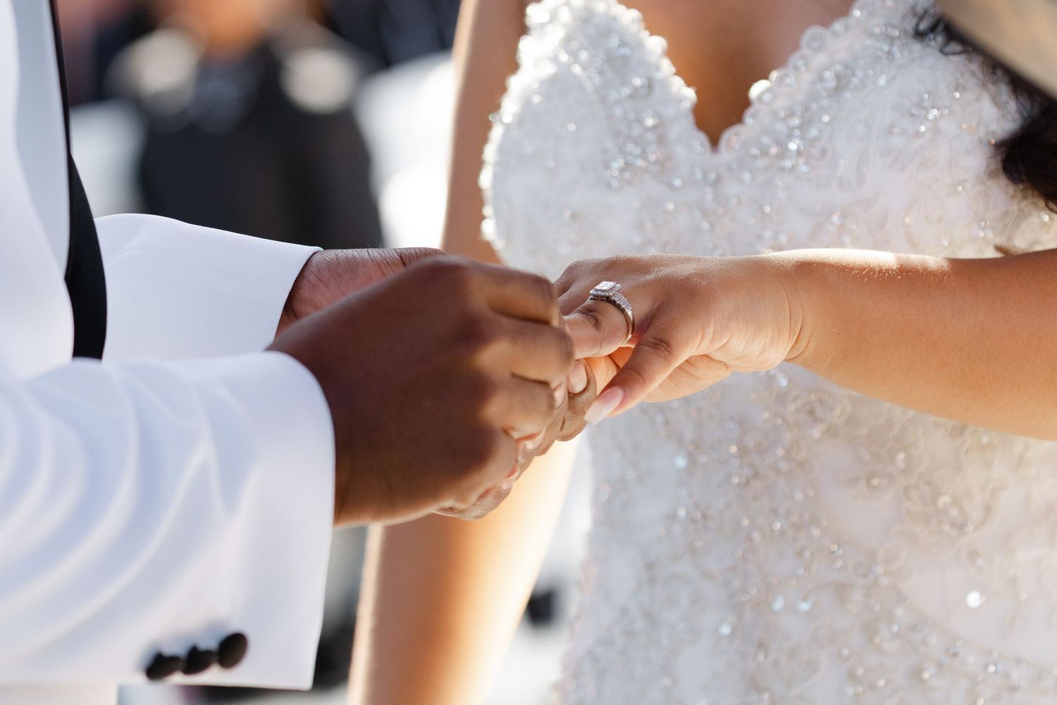 A close-up shot of someone signing a marriage license or legal document with a pen during a wedding ceremony.