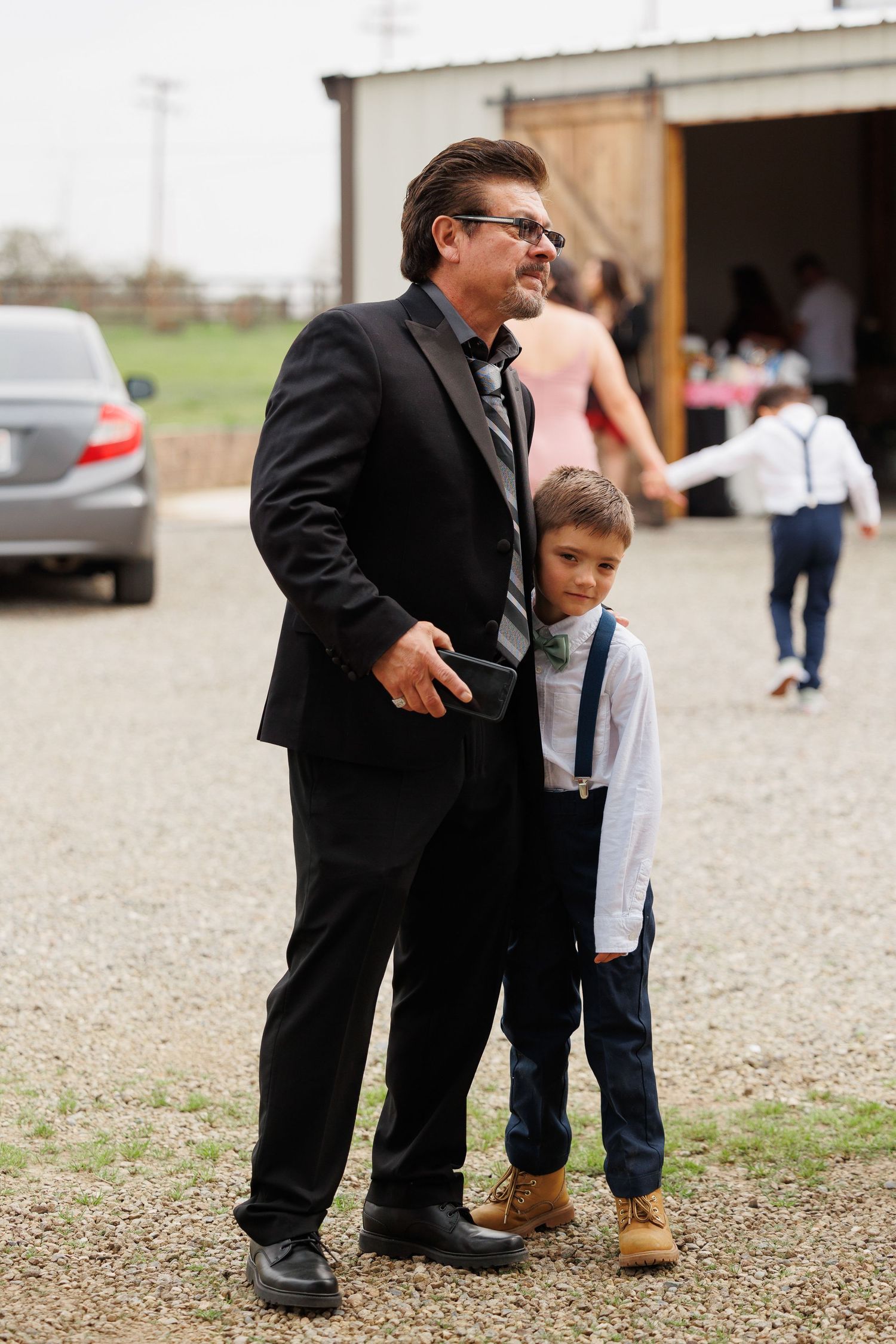 A series of cropped shots showing formal dress shoes and boots on gravel ground.