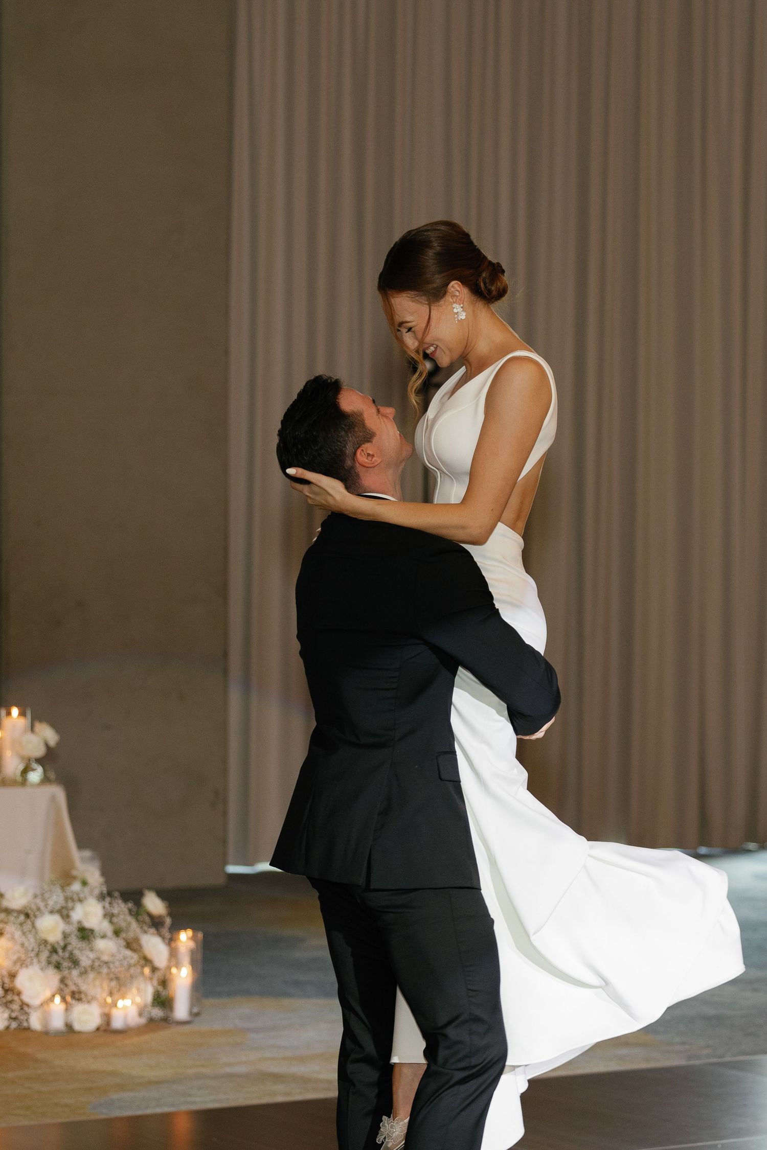 Romantic wedding couple shares intimate kisses in a sequence of four candid reception photos against neutral backdrop.