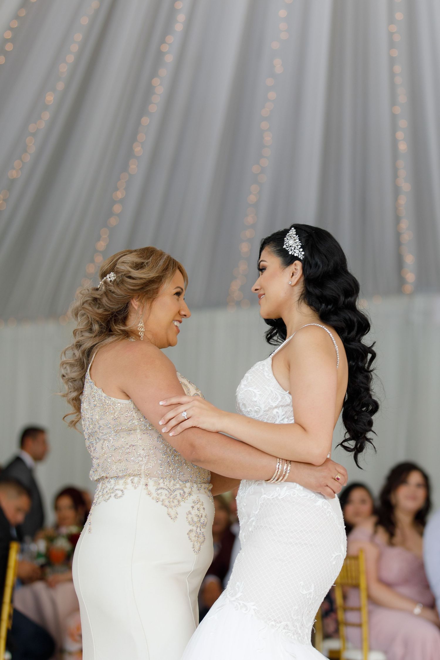 Two brides in white wedding dresses share a joyful moment together on their special day during a wedding reception.