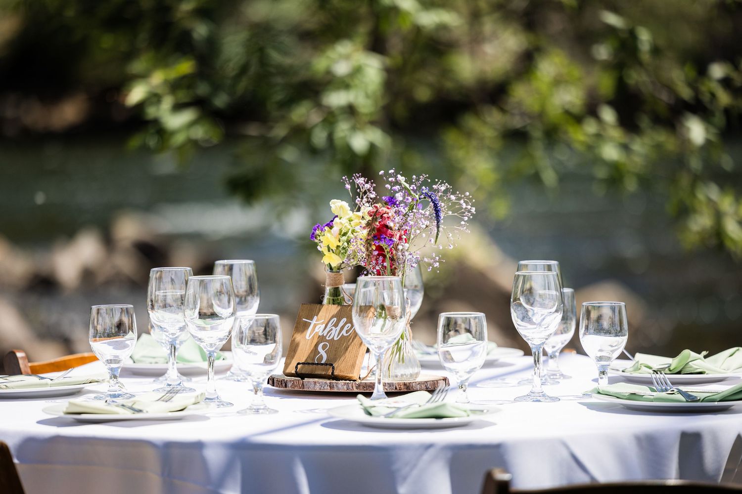 Elegant table settings with wine glasses and floral centerpieces at an upscale restaurant.