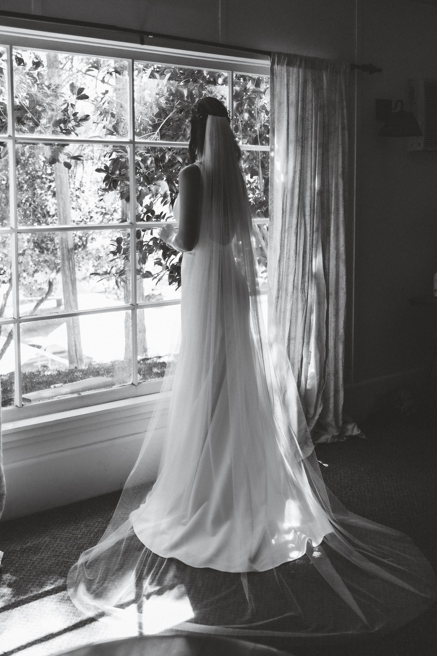 A series of ethereal black and white photos showing a flowing white wedding dress silhouetted against sunlit windows.