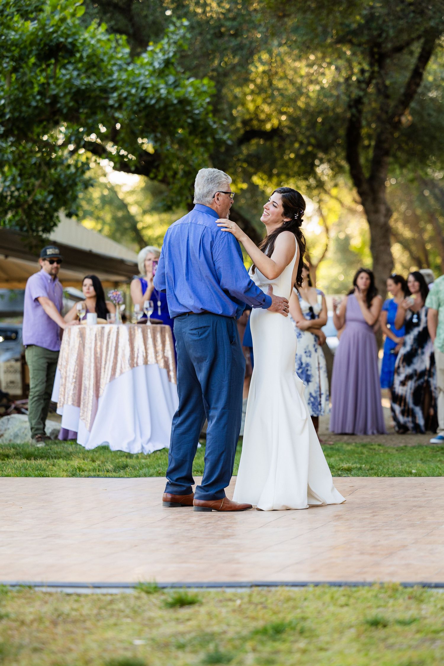 Wedding guests dance on an outdoor patio during a summer reception celebration.