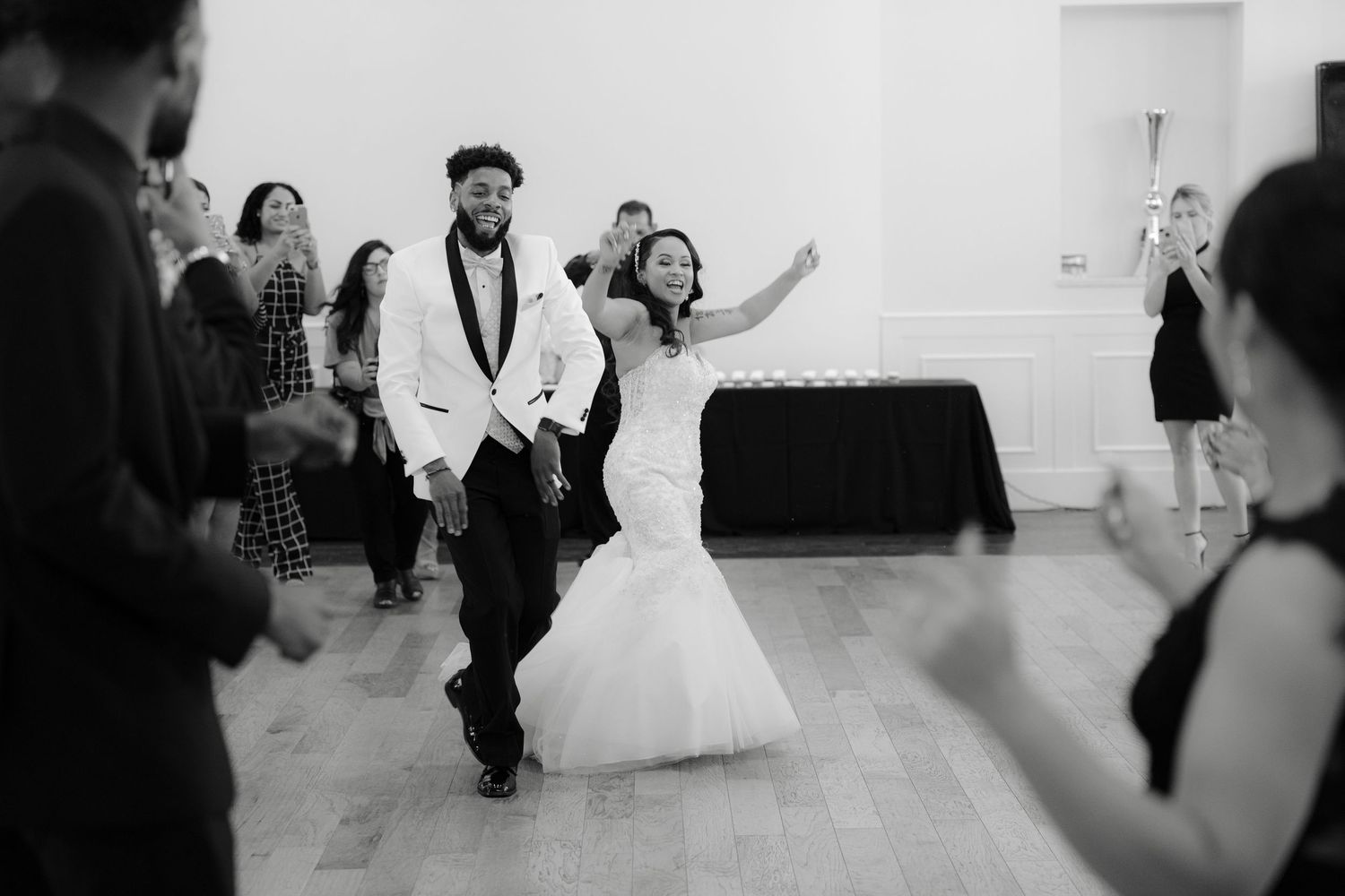 Black and white photos show a couple dancing at their wedding reception with guests looking on.