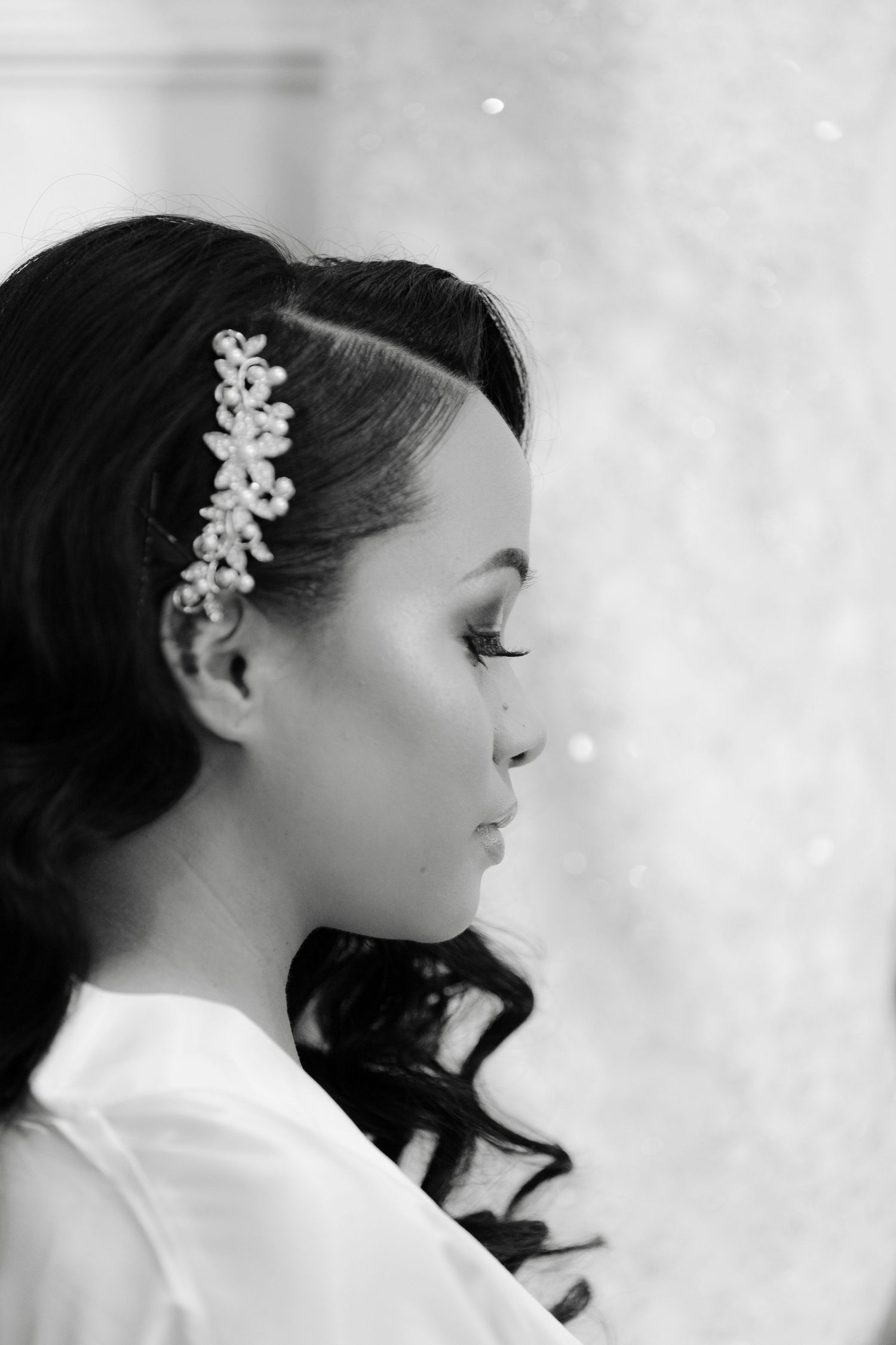 A series of profile views showing a person with dark hair wearing a white top and floral hair accessory in soft lighting.