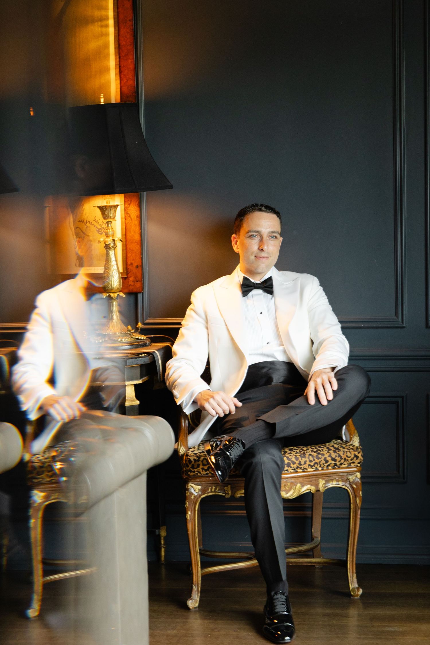 A motion blur sequence showing someone in a white tuxedo jacket seated on an ornate gold chair against a dark wall.