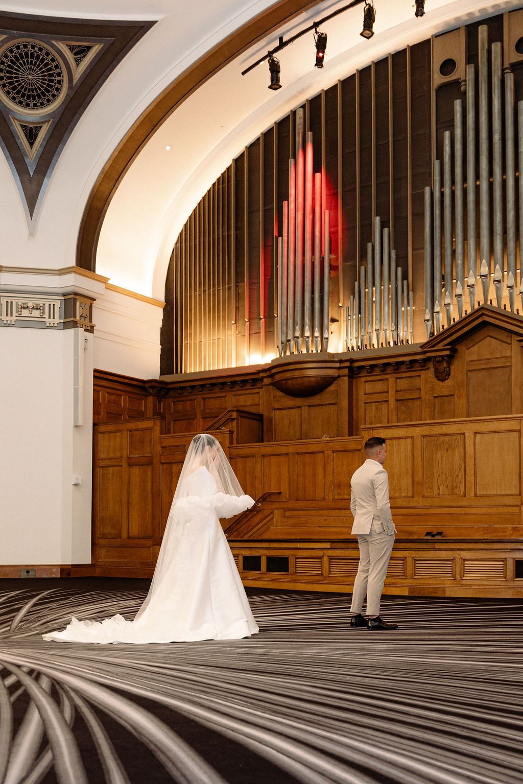 A wedding photography sequence in a grand hall with wooden paneling and organ pipes.