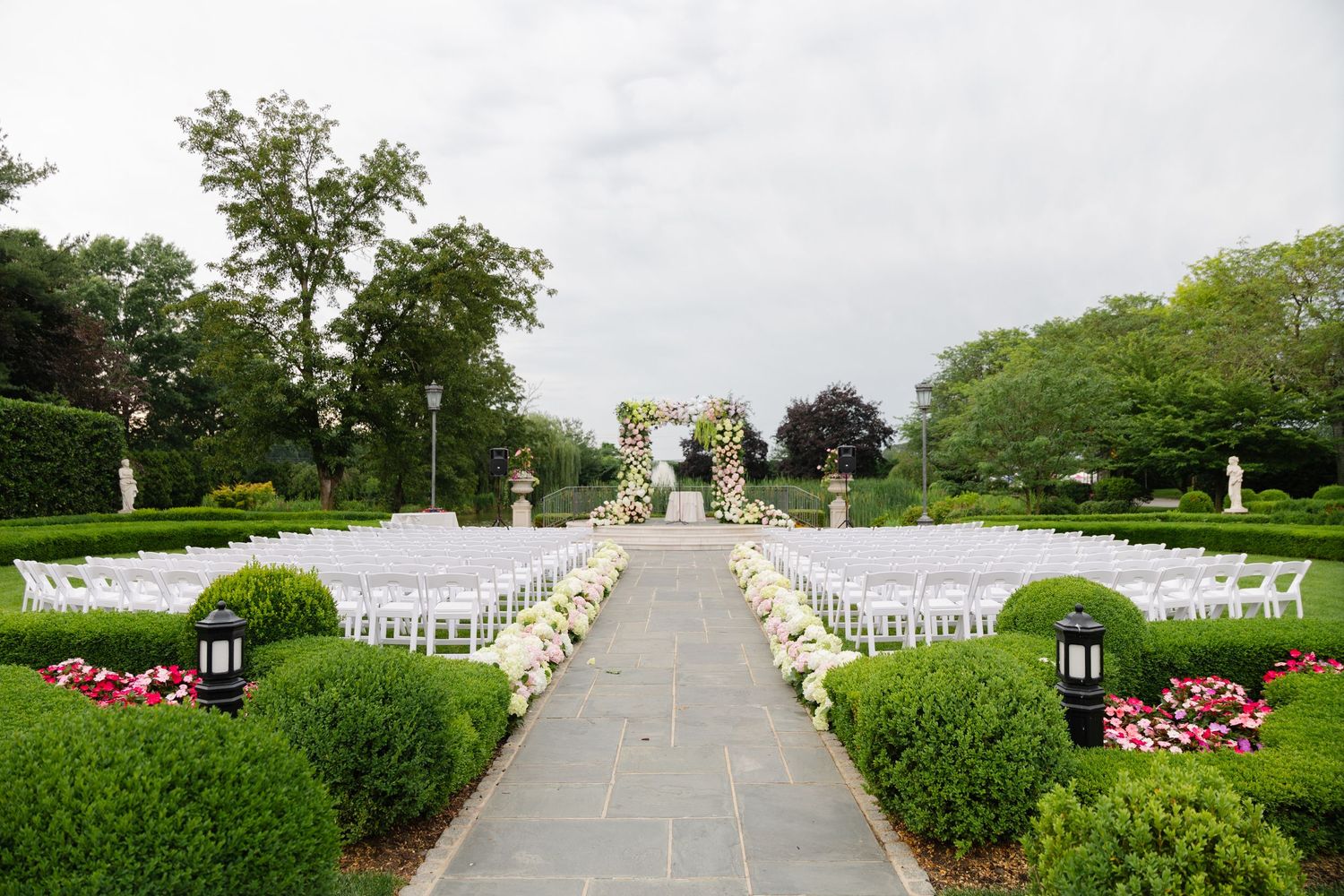 A panoramic view of Arlington National Cemetery showing rows of white headstones stretching across manicured green lawns.