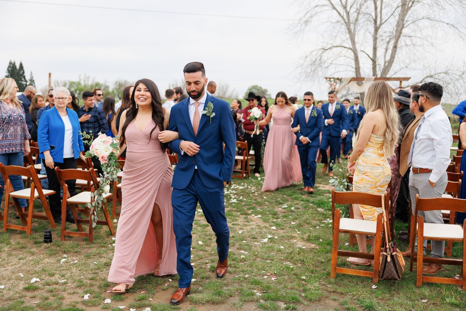 Wedding guests celebrate with sparklers during an outdoor evening reception at a rustic venue.