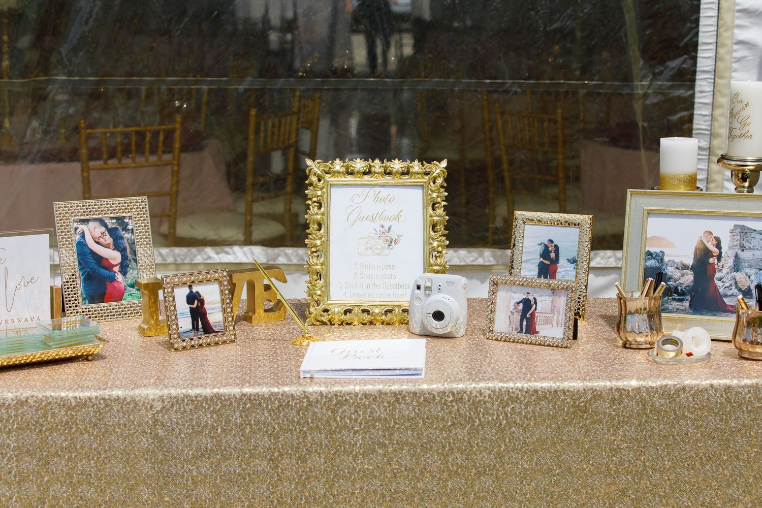A panoramic display of framed photographs arranged on a table at what appears to be a wedding reception or event.