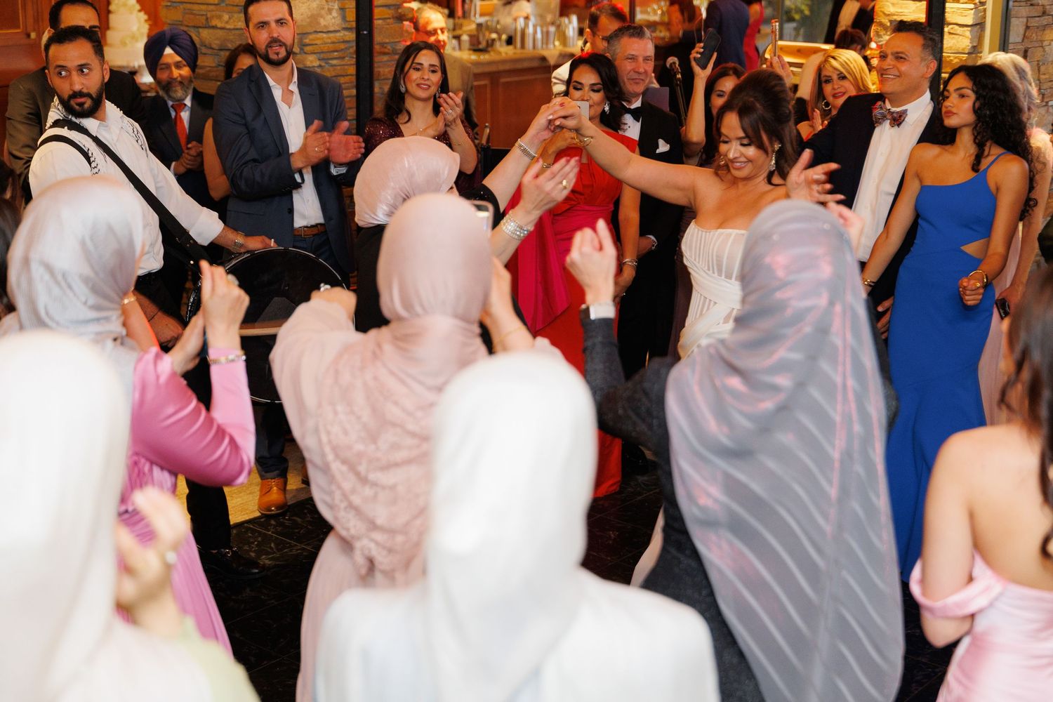Wedding guests dance and celebrate together on a festive dance floor during a reception party.