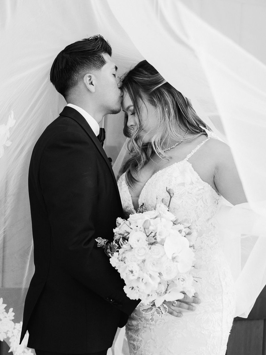 Intimate black and white wedding portraits under a flowing veil.