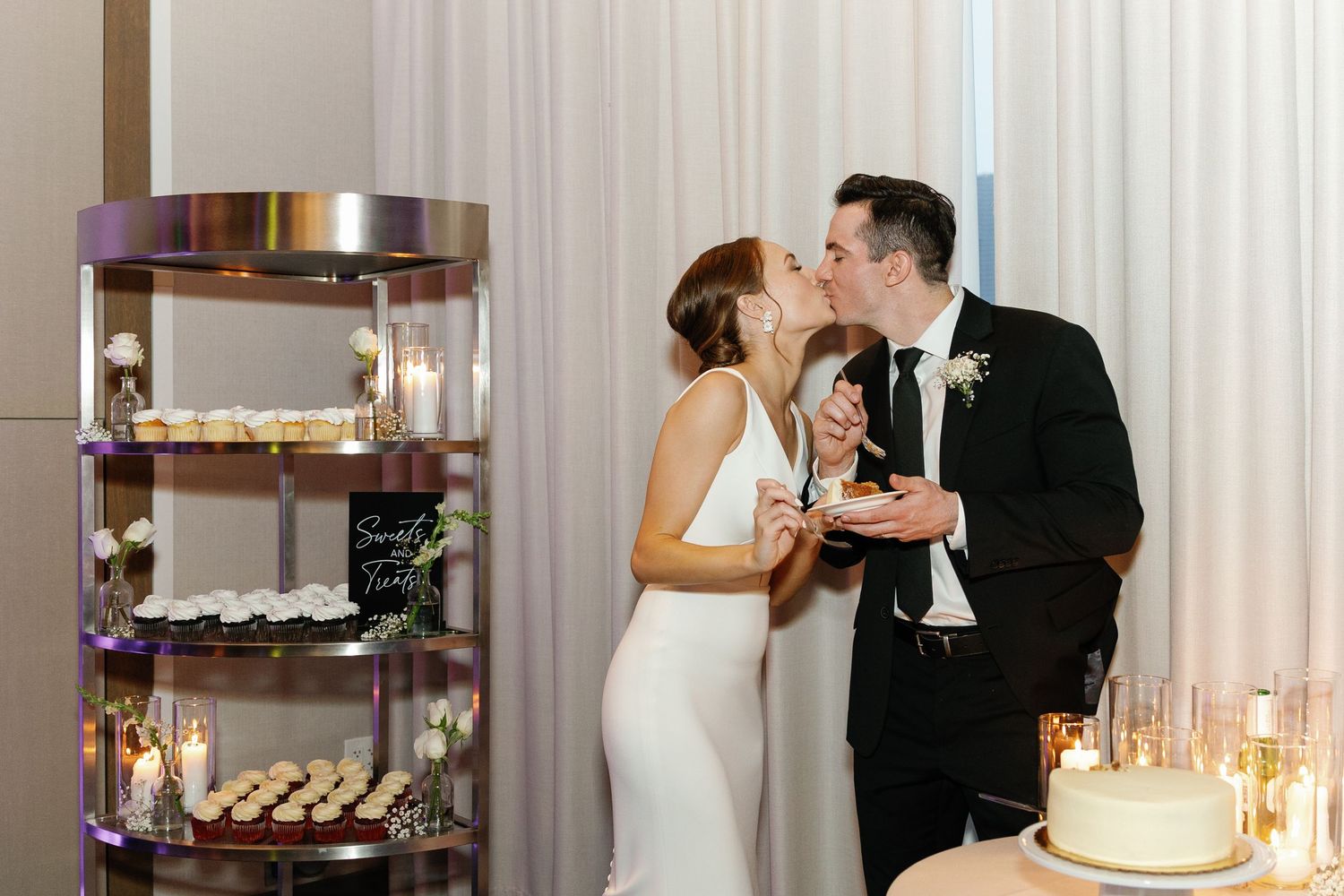 Candlelit wedding reception setup with dessert display and romantic ambiance.
