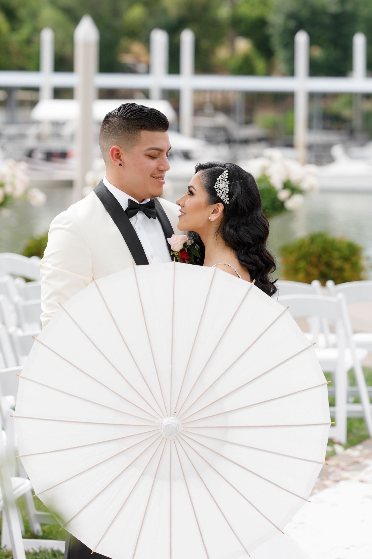 A couple poses behind a white parasol in a creative wedding photo series showing progressively closer romantic moments.