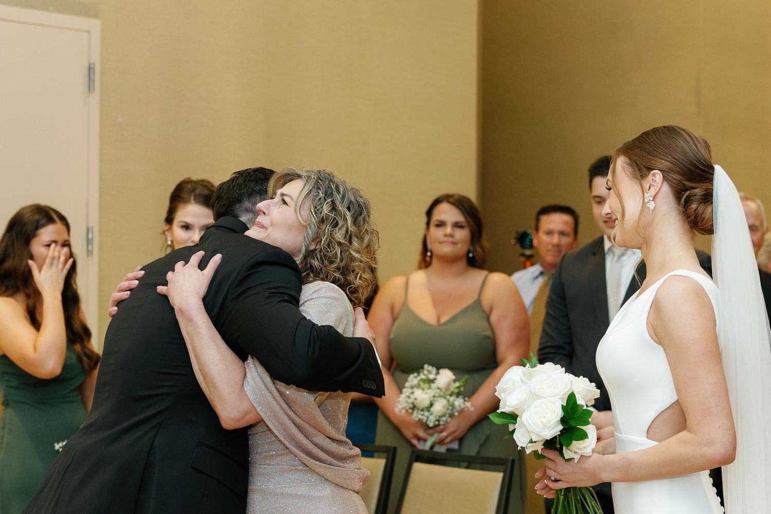 Wedding guests dance together in a reception hall with warm lighting and festive atmosphere.