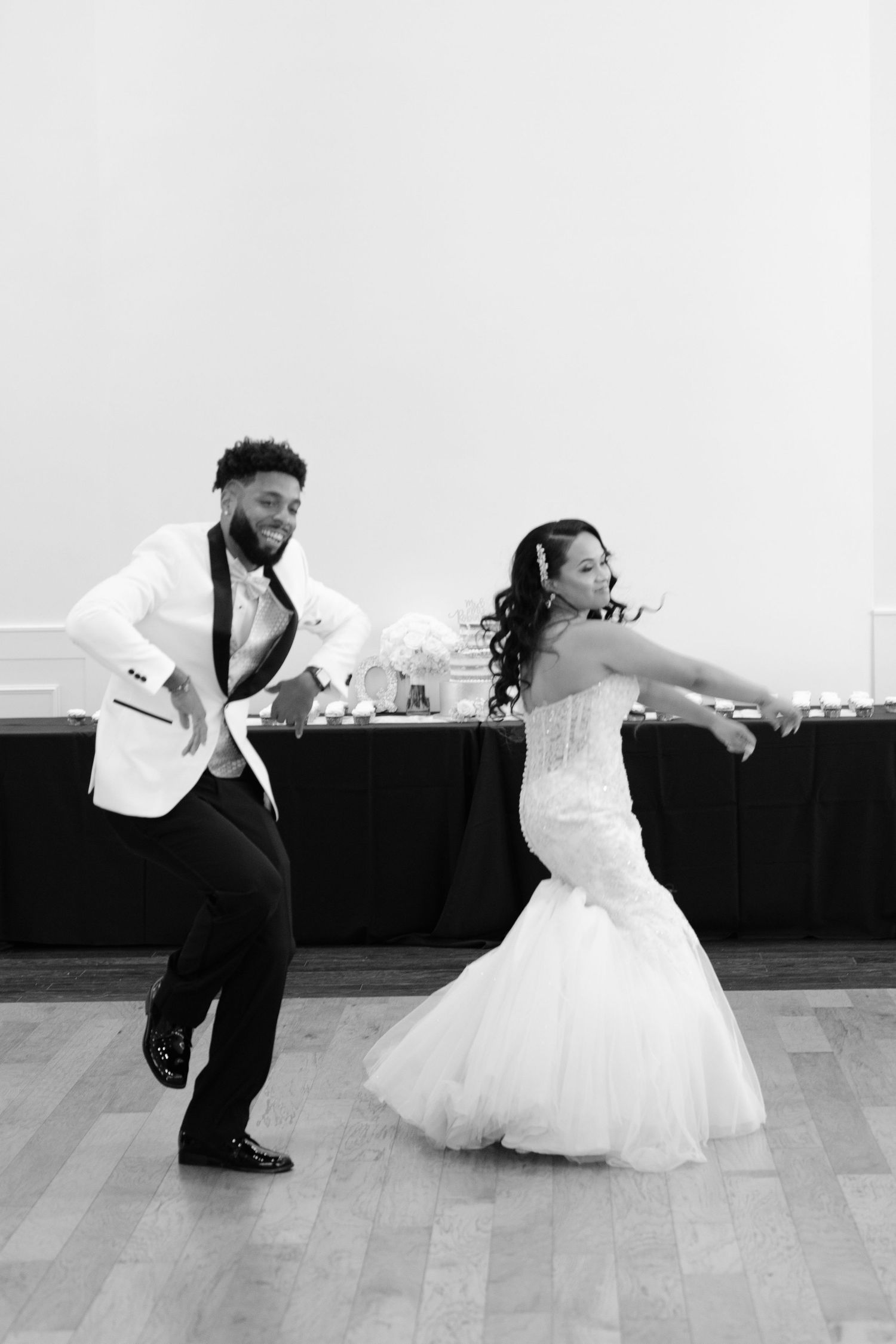 A black and white photo series shows a couple dancing together in wedding attire on a wooden dance floor.