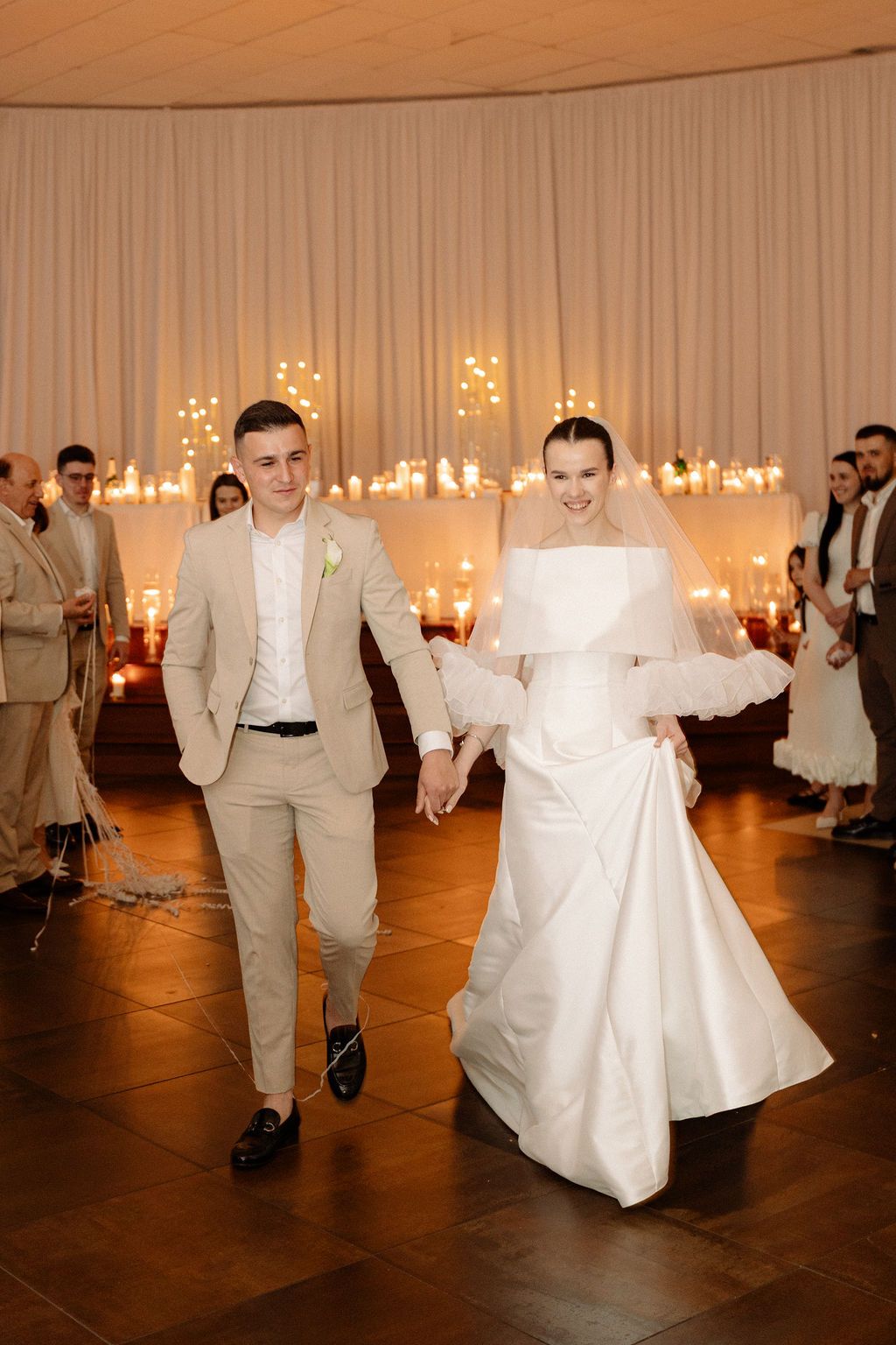 Wedding reception dance floor with couples in white dresses and tan suits moving in formation.