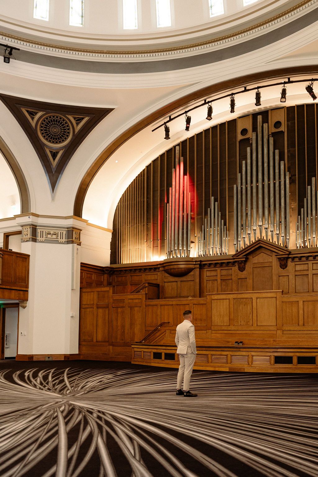 Architectural sequence showing interior of church or concert hall with grand pipe organ and curved ceiling details.