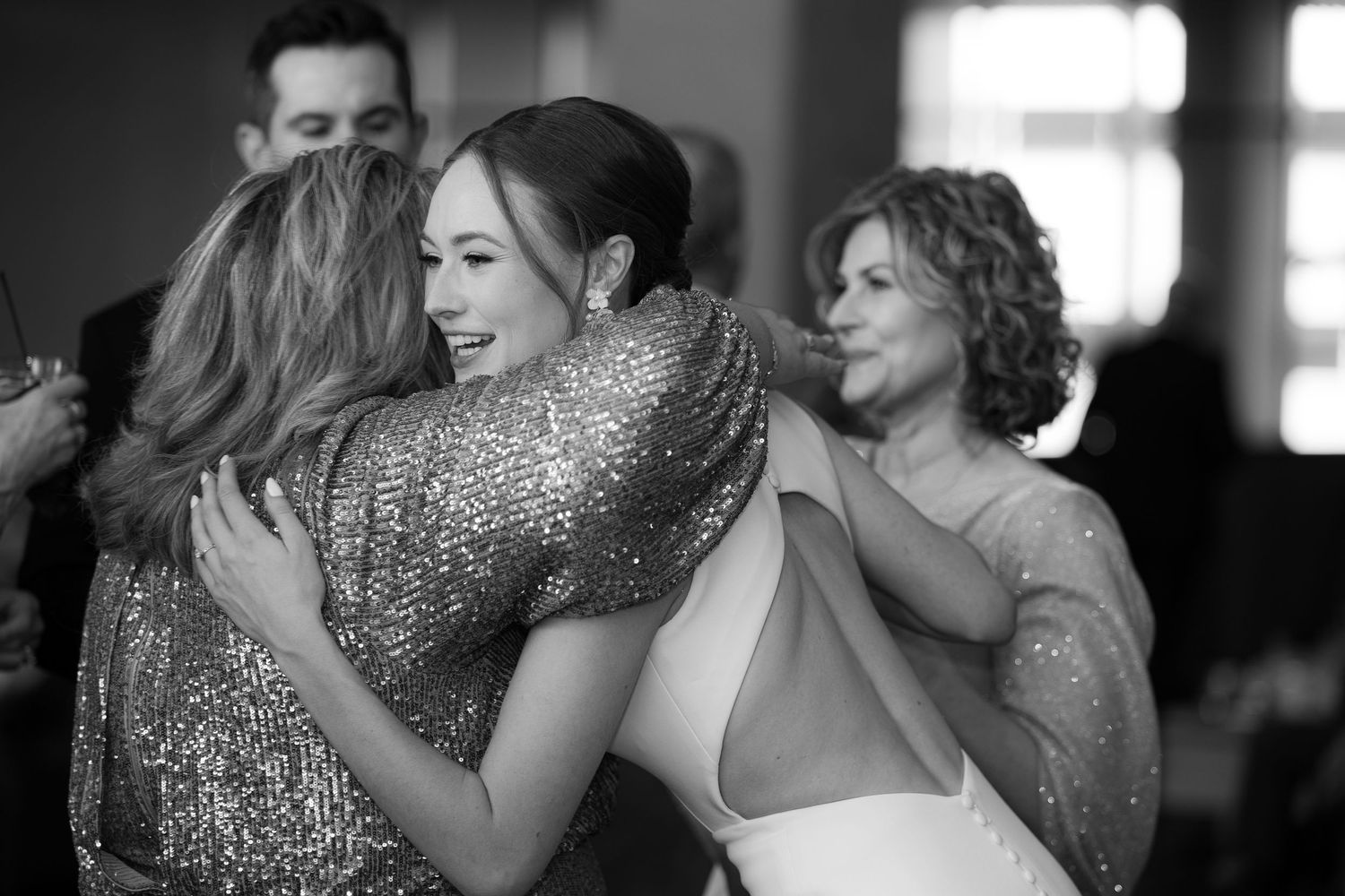 A tender embrace between two people at a formal event, captured in black and white photography.