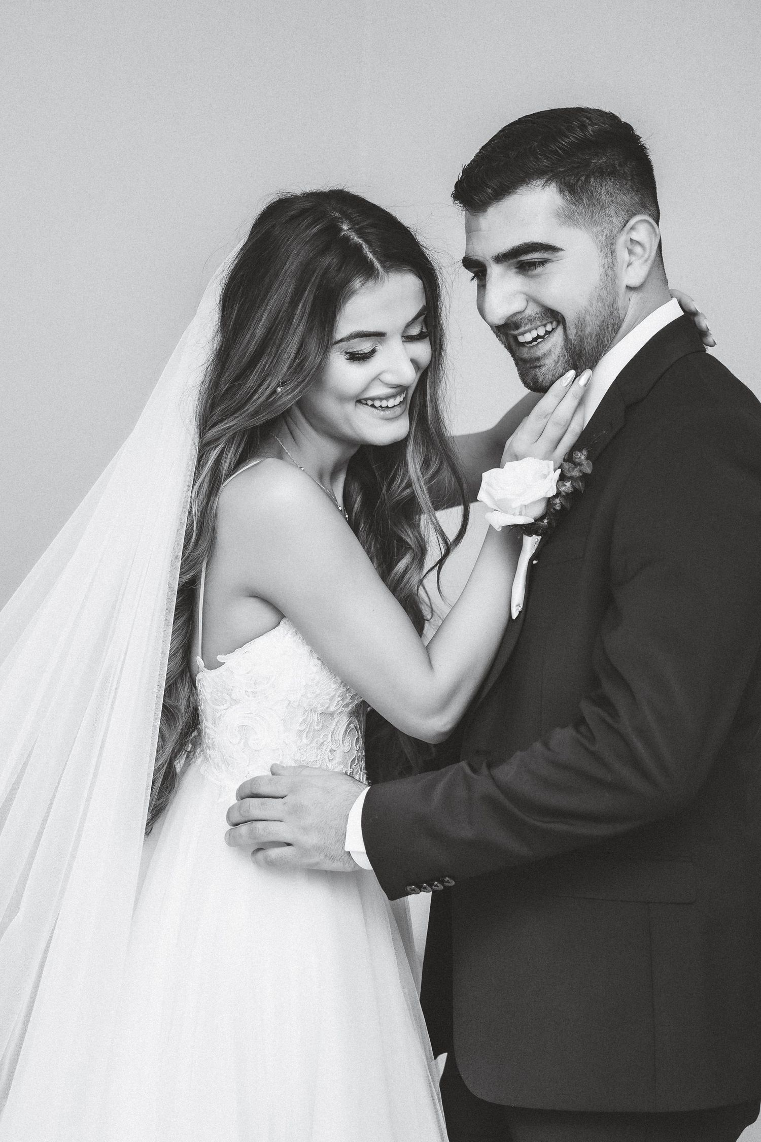 Black and white wedding photos showing tender moments between newlyweds in formal attire.