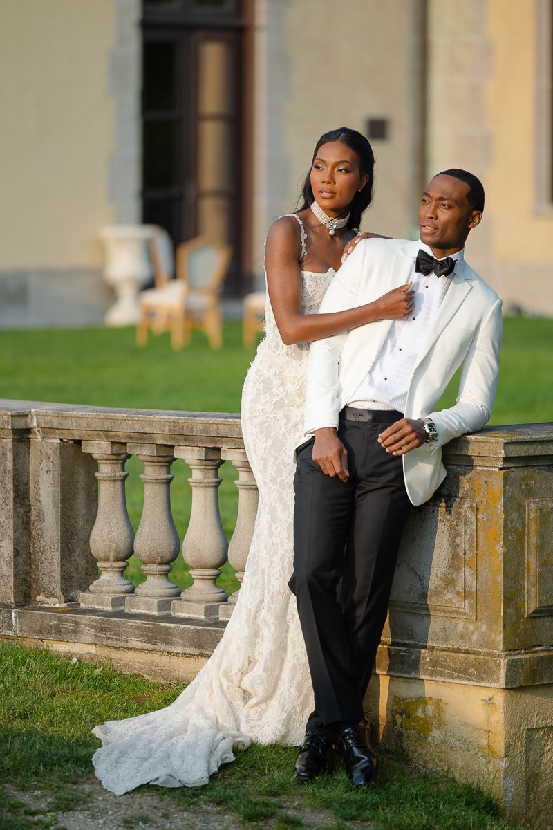 Newlyweds share intimate moments along an ornate stone balustrade.