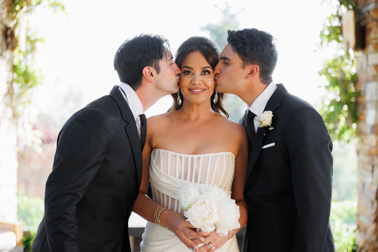 A bride and groom share intimate moments during a wedding photo session in a garden setting.