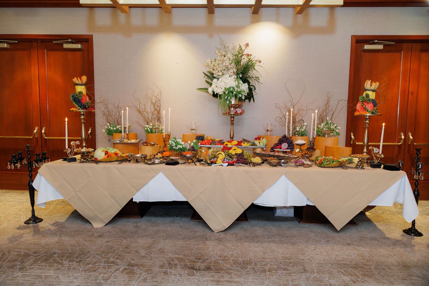Long banquet tables adorned with elegant floral arrangements and candelabras set up for a formal event.