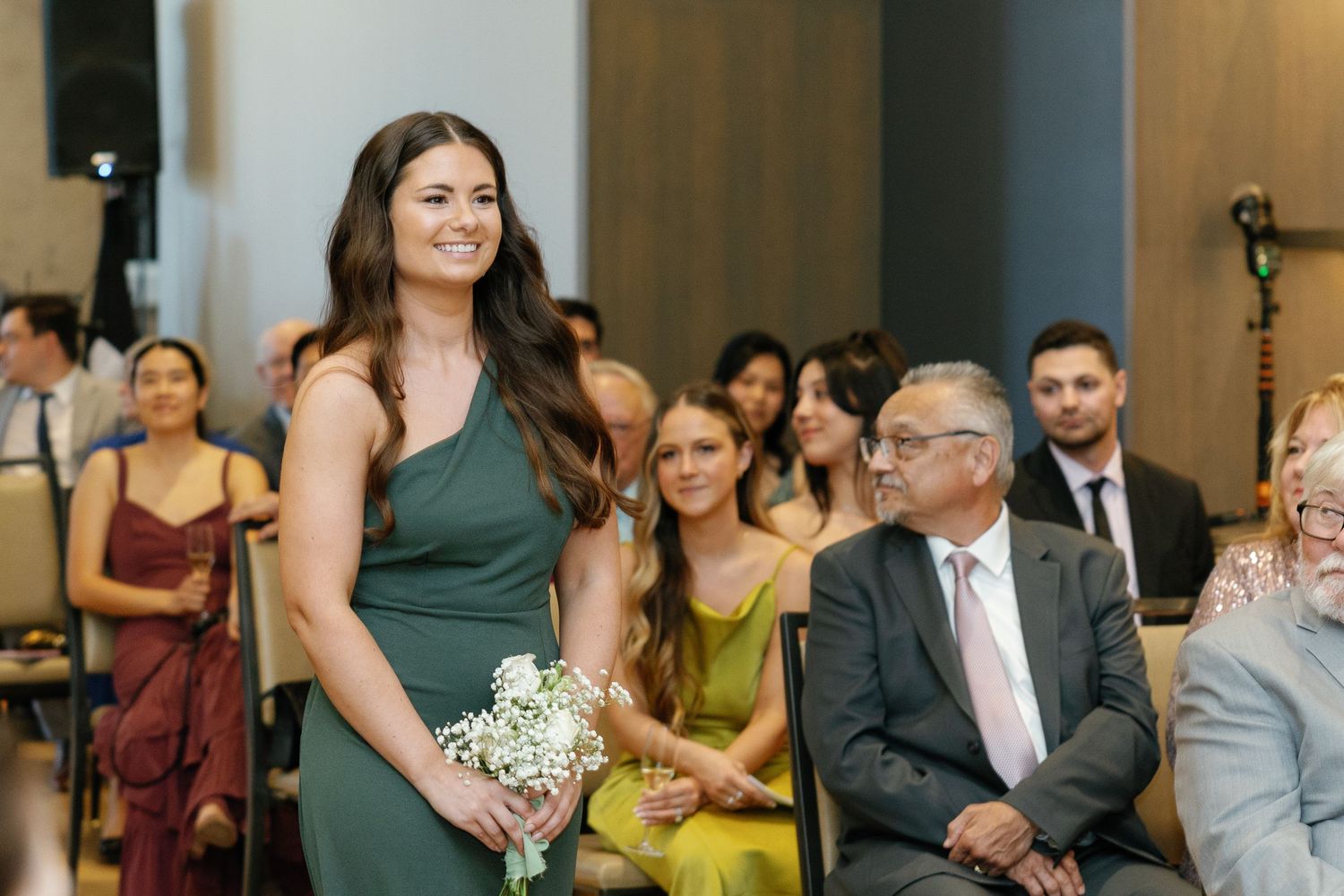 Wedding guests smile and laugh during a reception celebration in an elegant indoor venue.