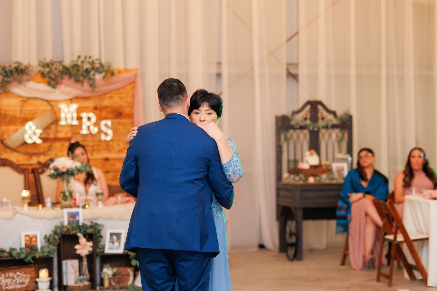 A couple in formal attire dances together during a wedding reception in an elegant ballroom.