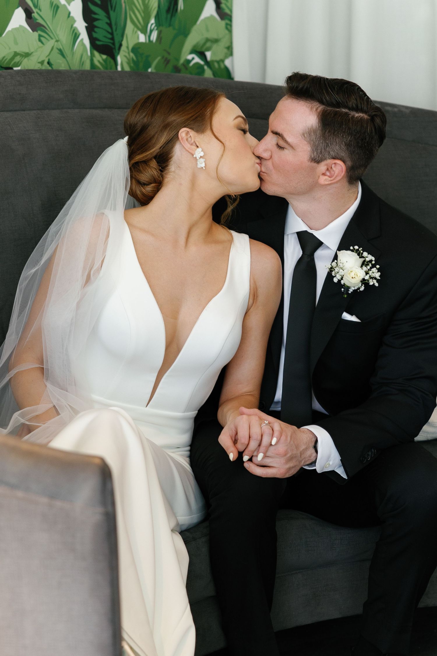 A romantic sequence of wedding photos showing a couple sharing tender kisses while seated on a dark couch.