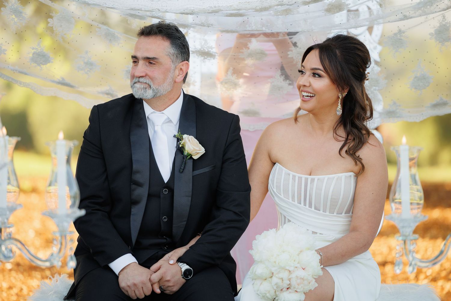 A joyful bride and groom share a candid moment together outdoors during their wedding celebration.