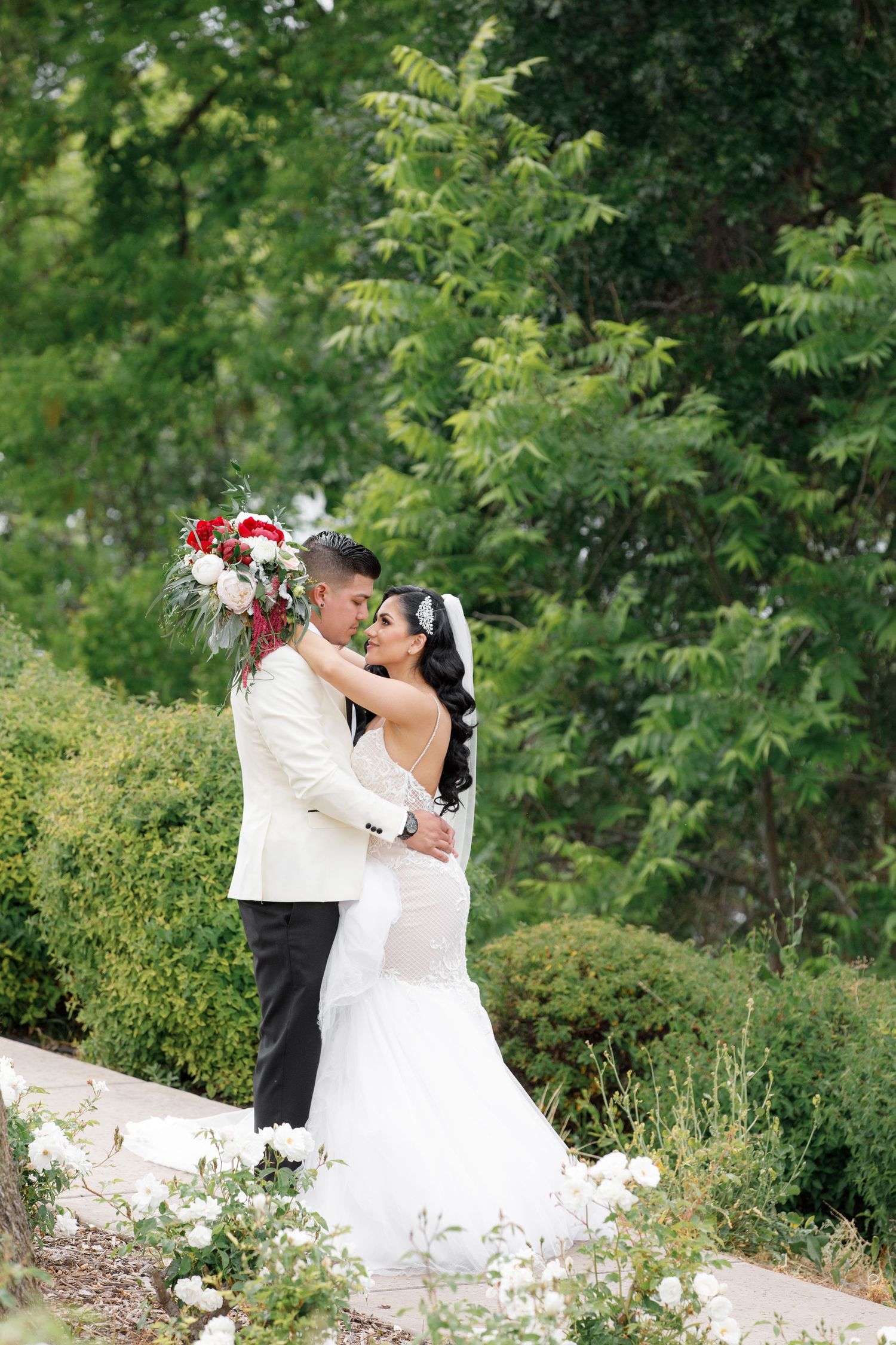 Garden wedding photo sequence with lush greenery and white florals creating a romantic backdrop.