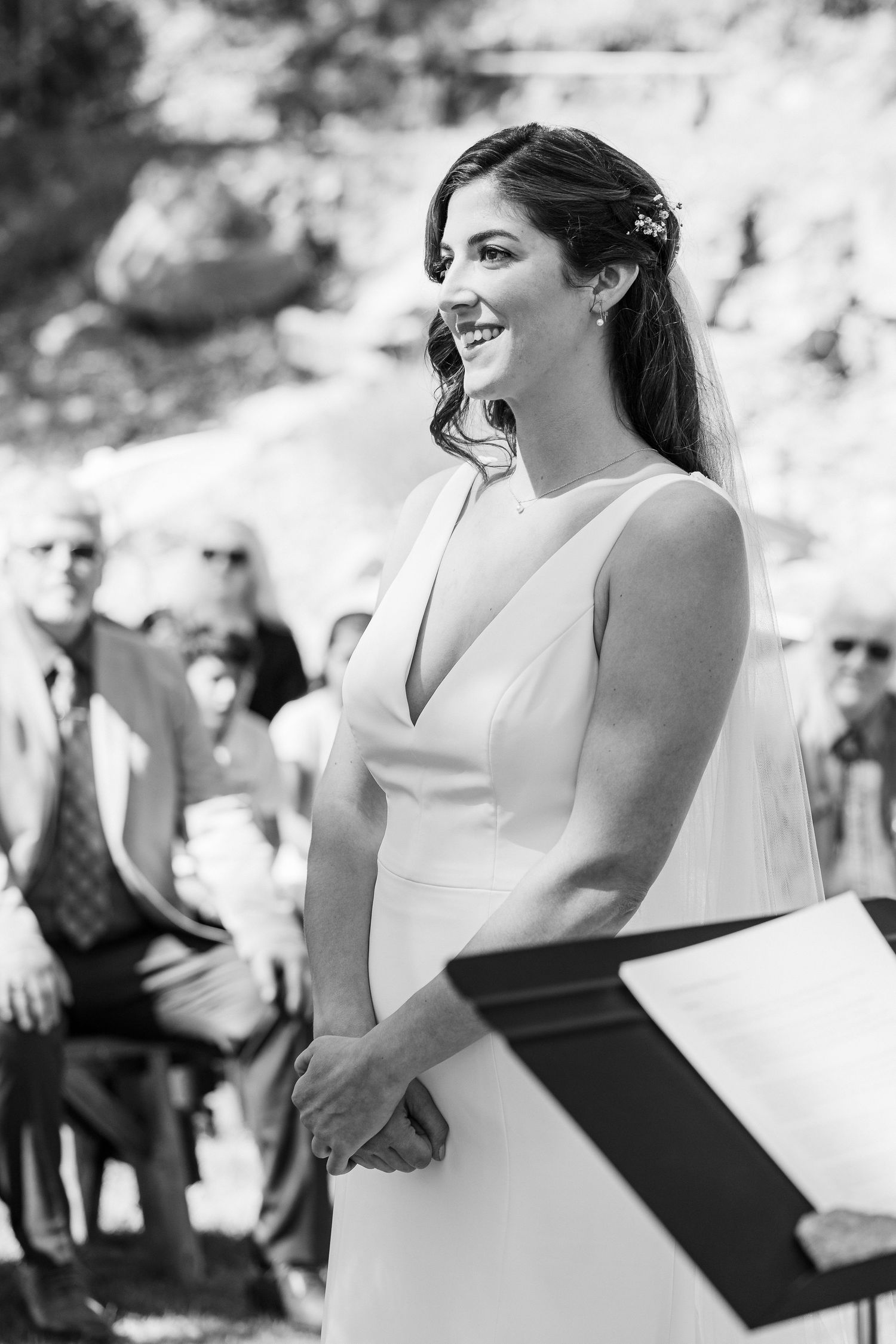 Black and white photo sequence showing a bride in a sleeveless white dress during an emotional outdoor ceremony moment.