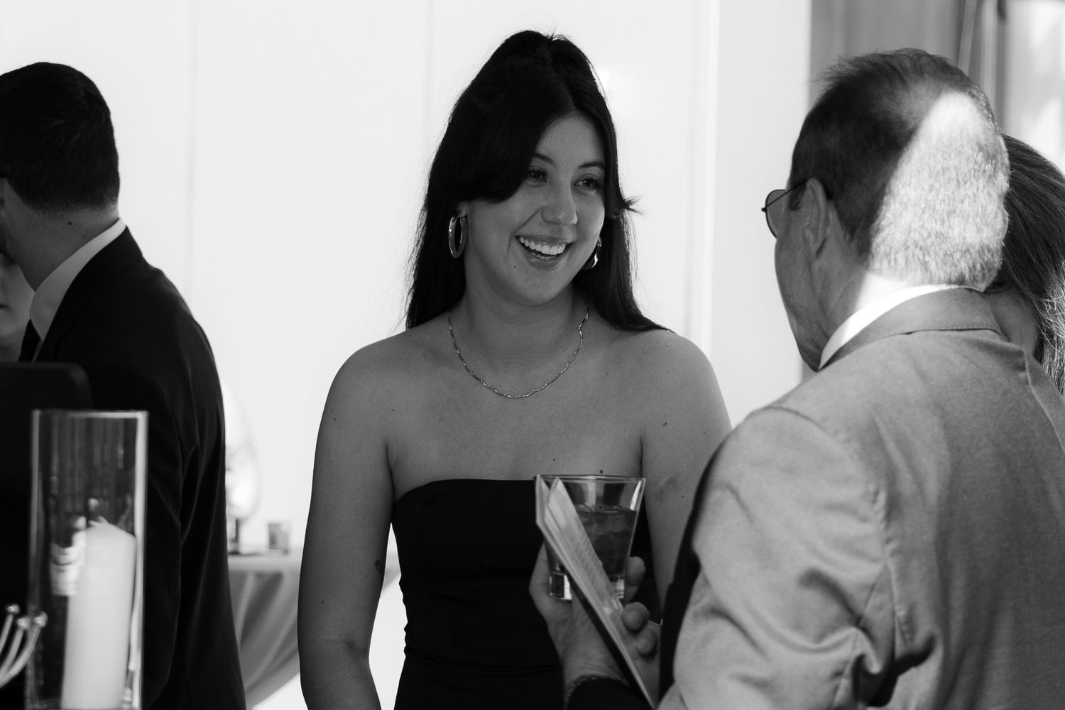 A collage of black and white wedding photos showing candid moments between people at a celebration.