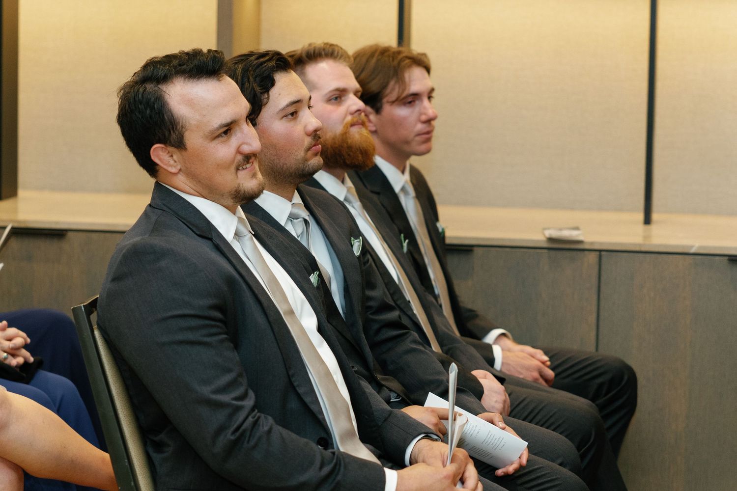 Business professionals seated in a row during a corporate meeting or presentation in a conference room.