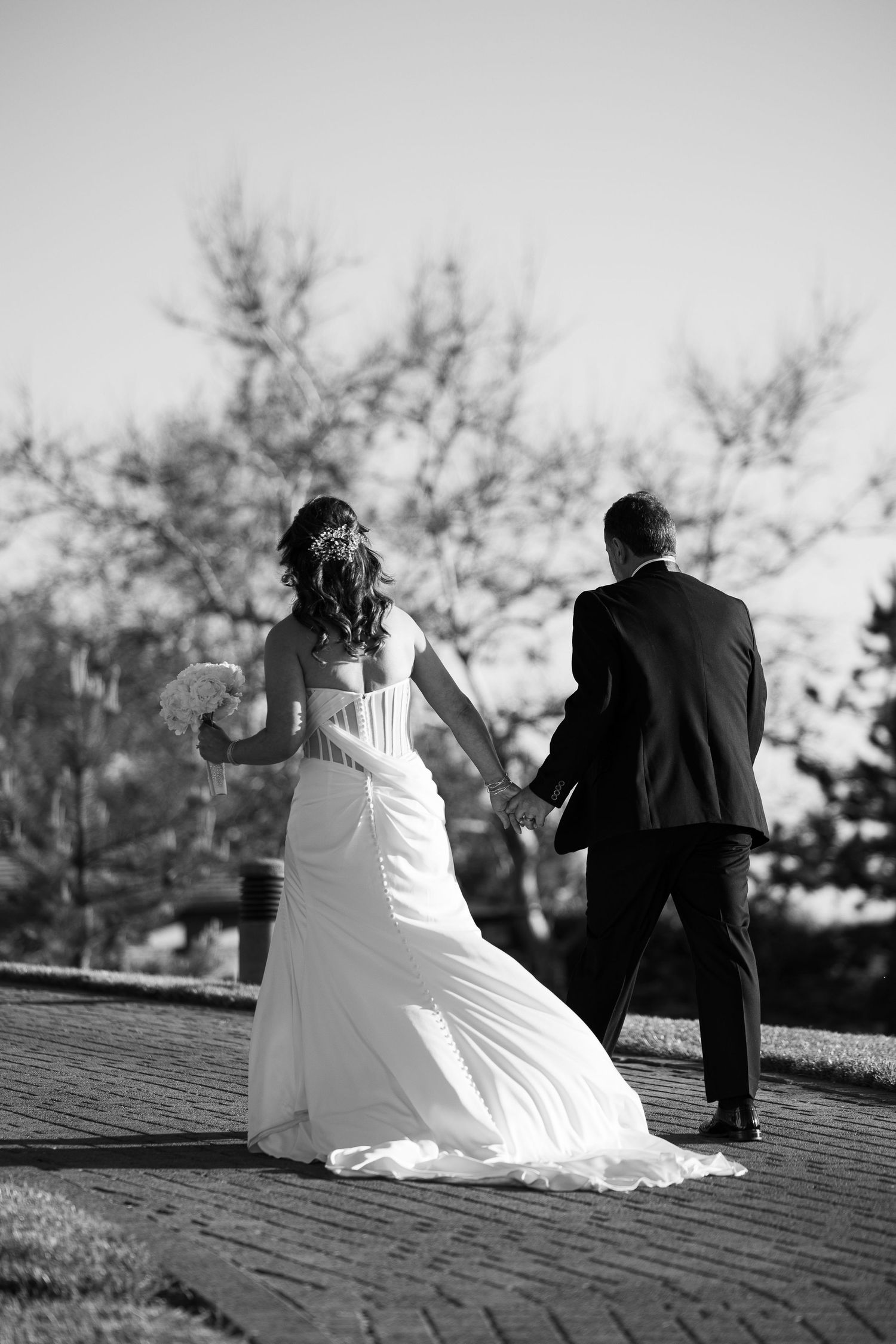 A black and white series of wedding photos showing a couple sitting together on a rooftop in romantic poses.