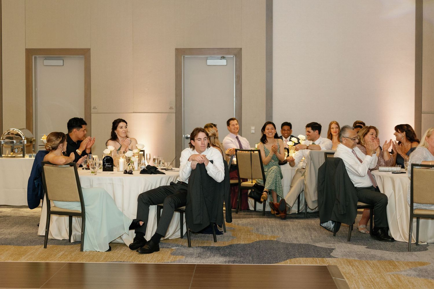 People seated in rows at a business conference or training session in a bright modern meeting room.