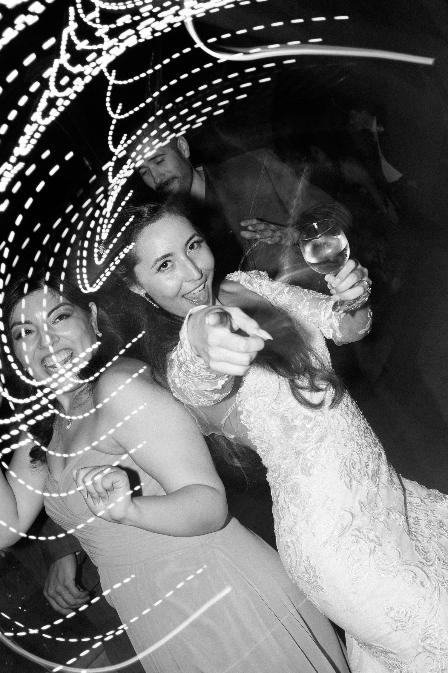 Artistic black and white shots capture bride's candid laughter during wedding celebration under decorative lights.