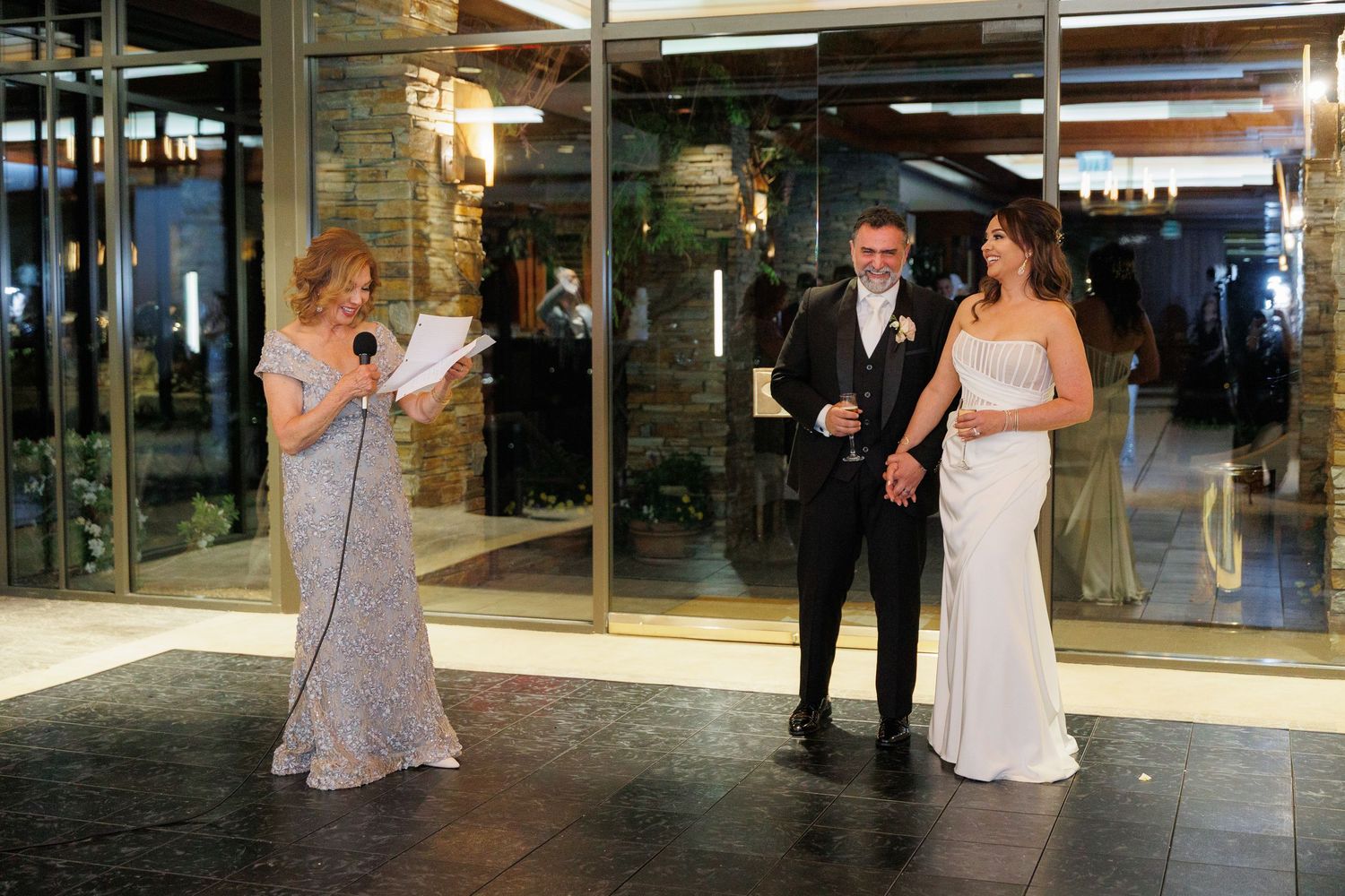A couple shares their first dance at a wedding reception in an elegant venue with warm lighting.