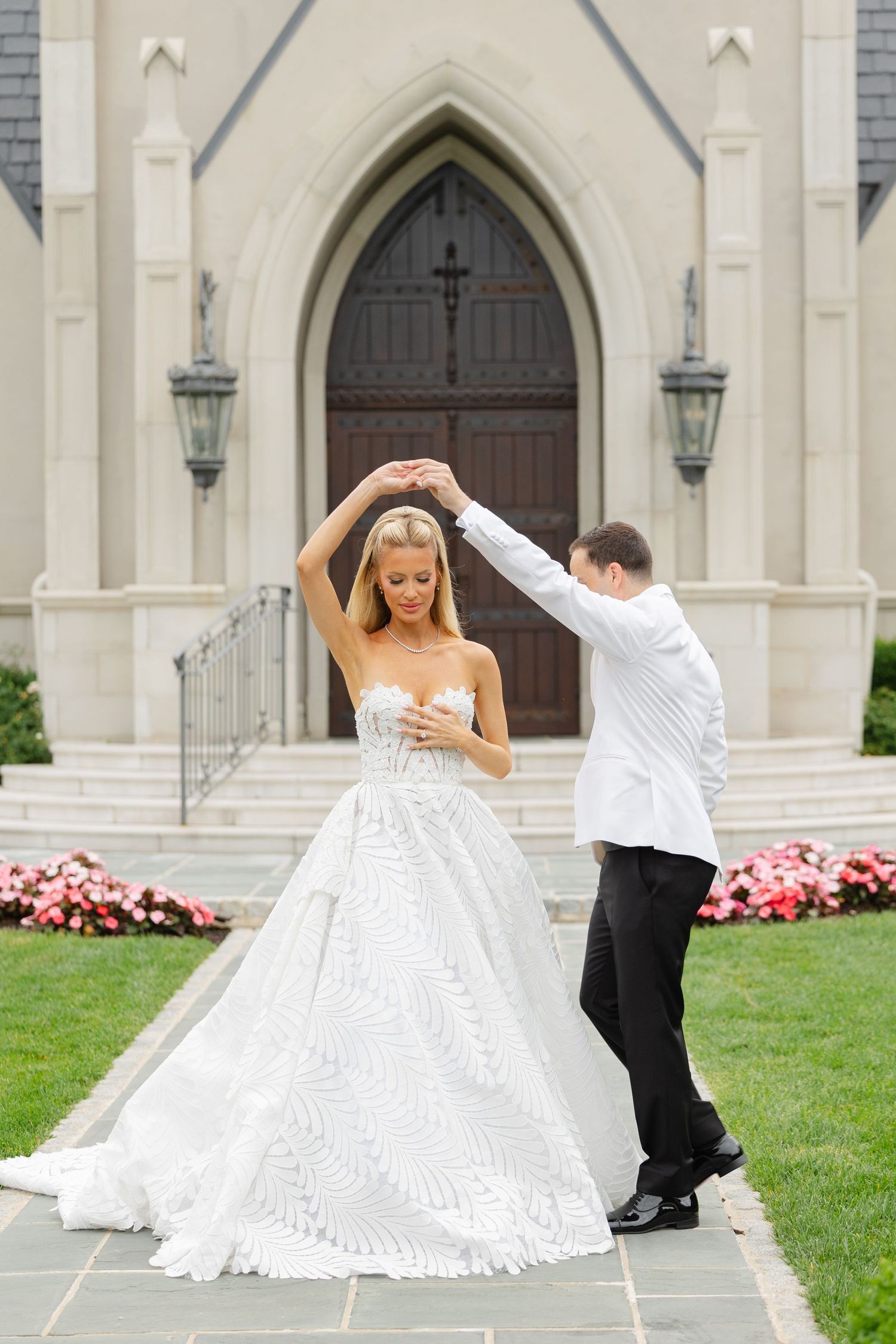 Romantic wedding photo series showing playful moments between bride and groom dancing outside a grand church.