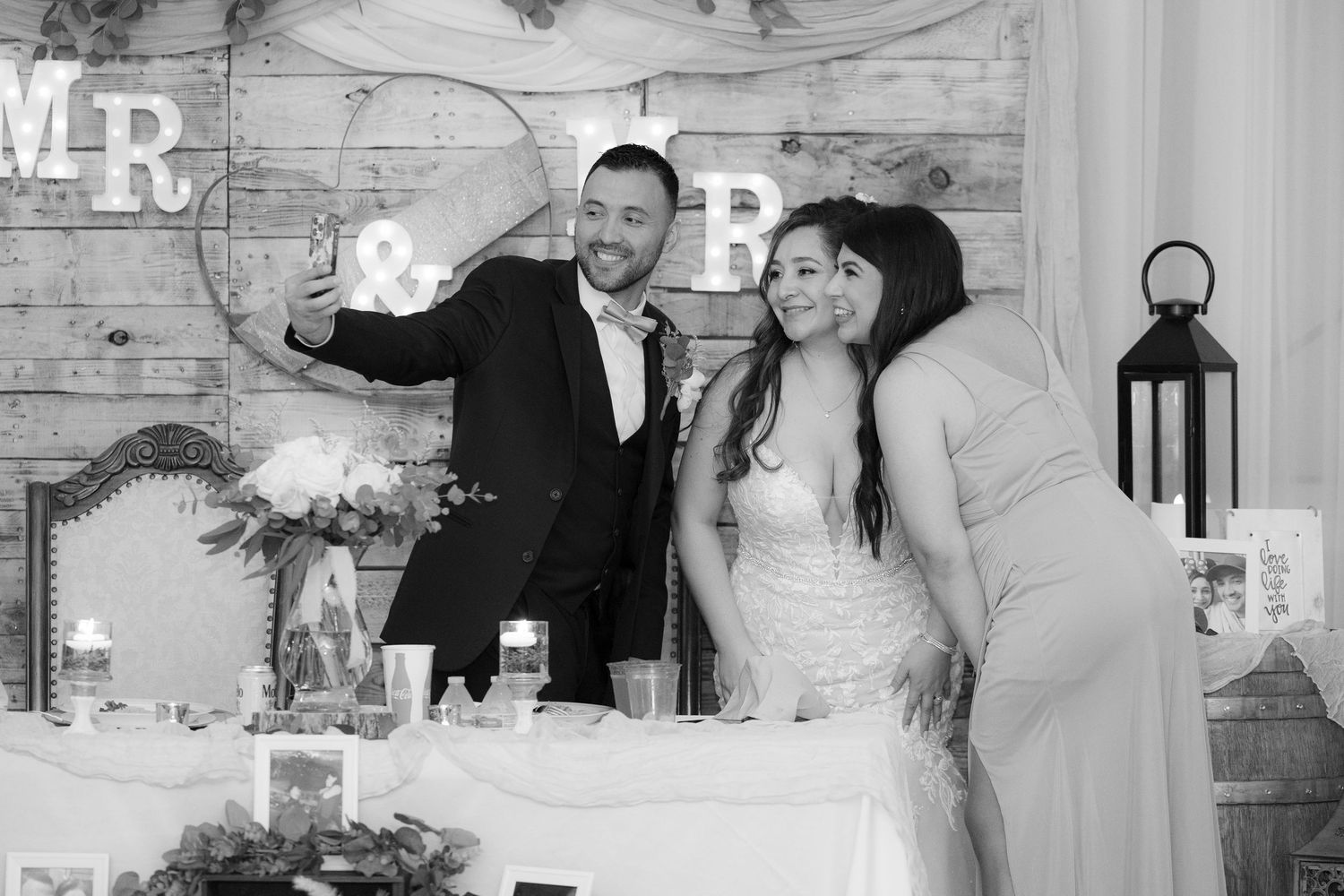 A collage of black and white wedding photographs showing romantic moments and celebrations at a rustic venue.